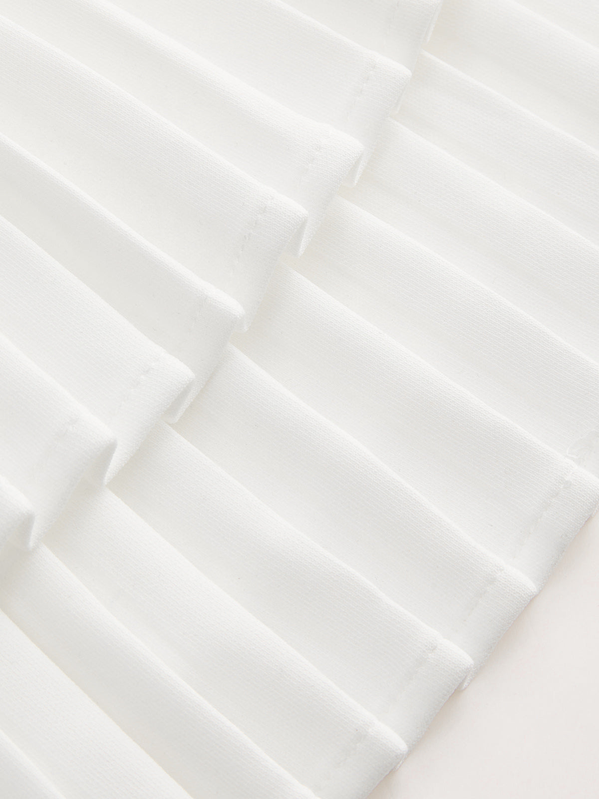 Hermine white mini dress, close-up of the knife-pleated skirt