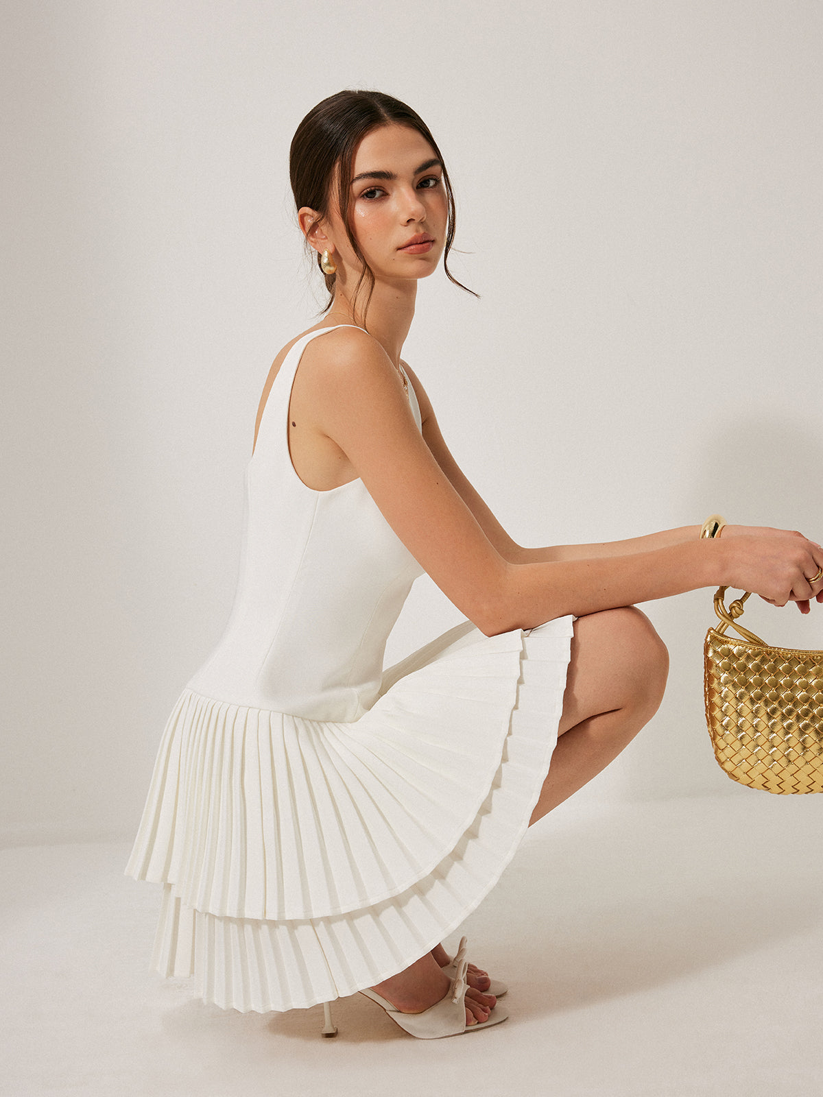 Hermine white pleated mini dress, side view seated