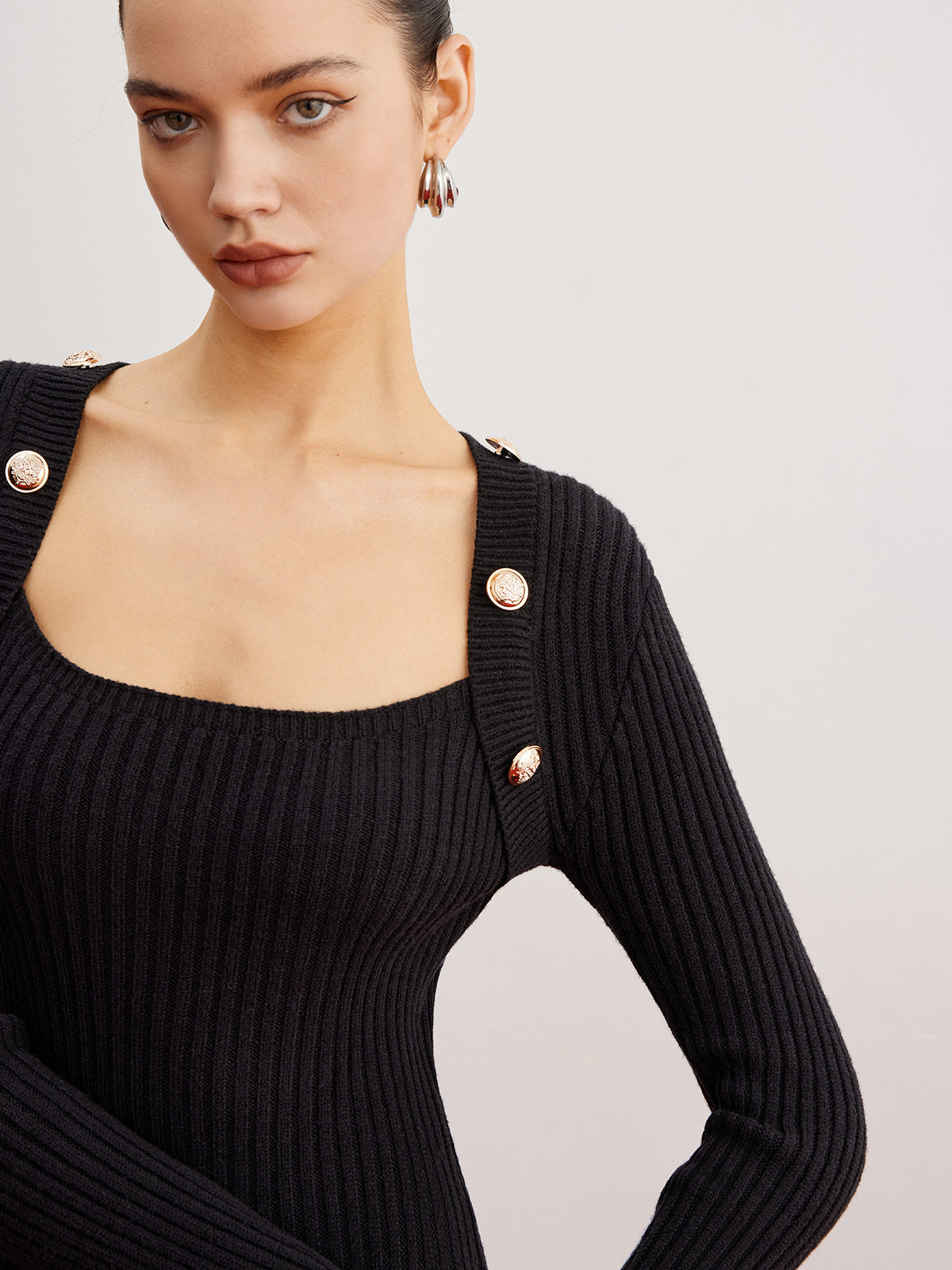 Éléonore black mini dress, close-up of the square neckline and gold-tone shoulder buttons