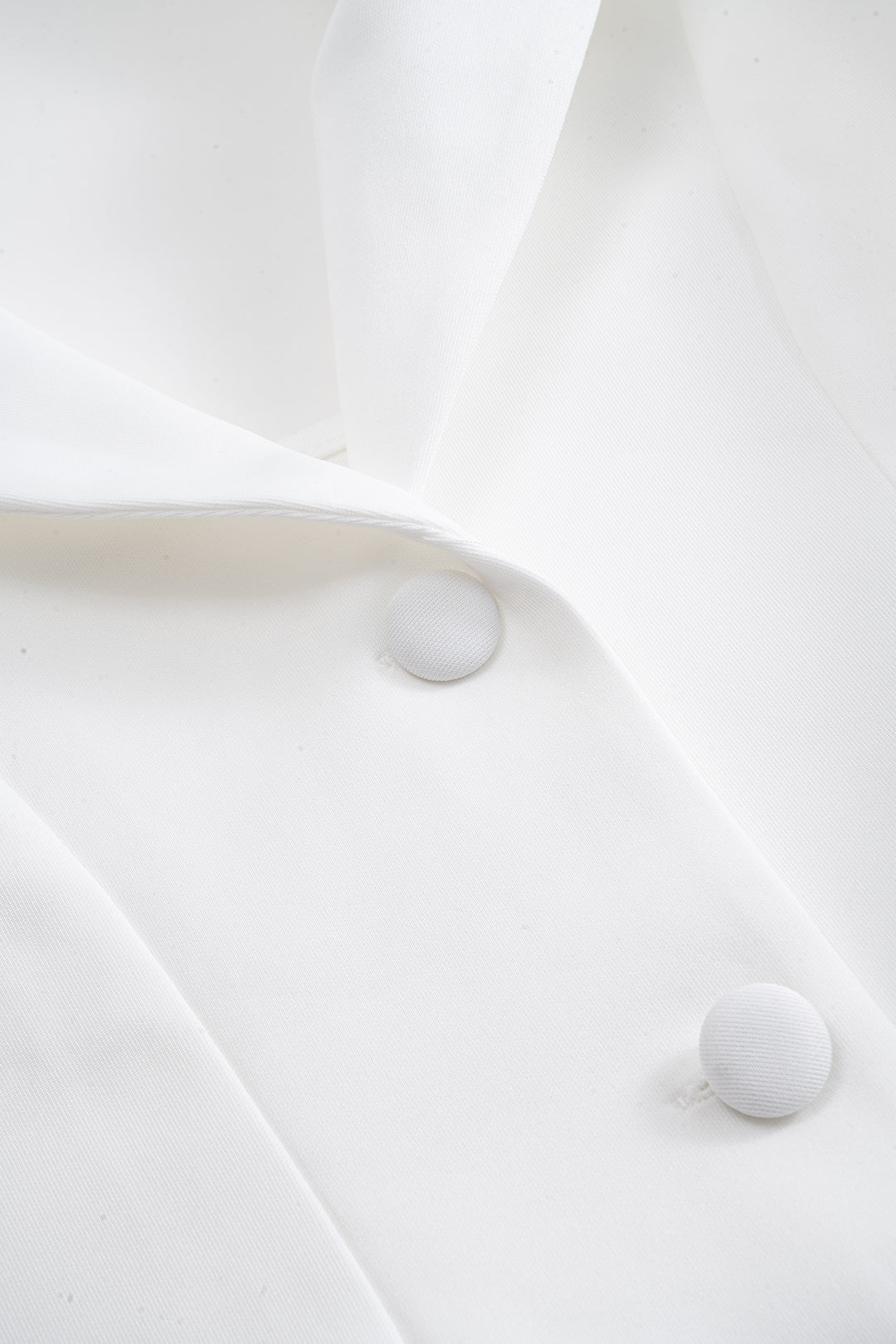 Cream mini dress, close-up of the covered buttons and lapel