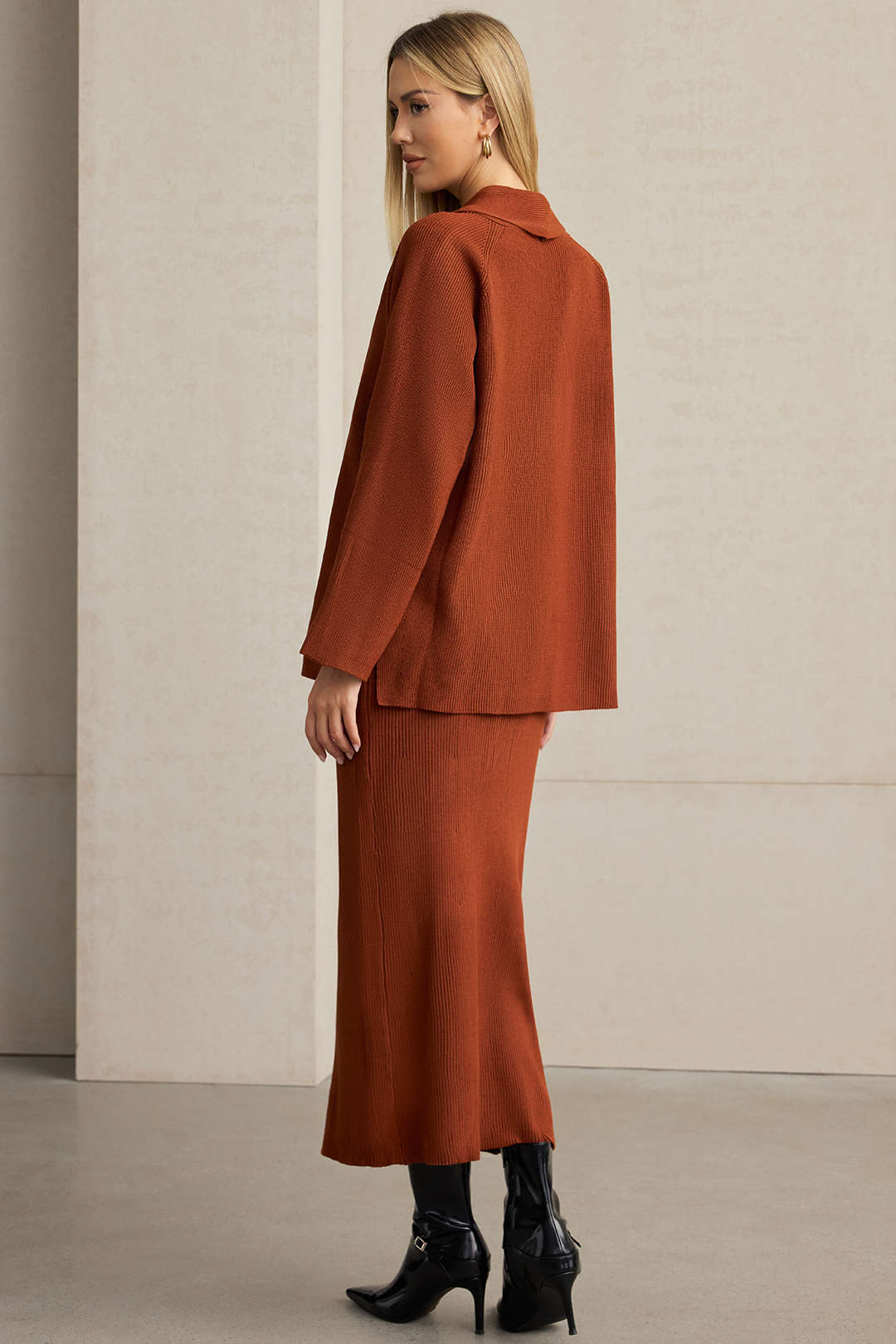 Side view of the rust knit blazer and ribbed midi skirt set