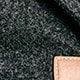 Close-up of the flecked dark grey fabric of the Apolline coat