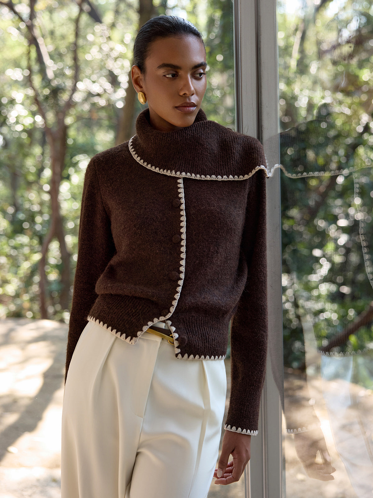 Armelle brown and cream crochet-trim cardigan with the collar worn up, front view