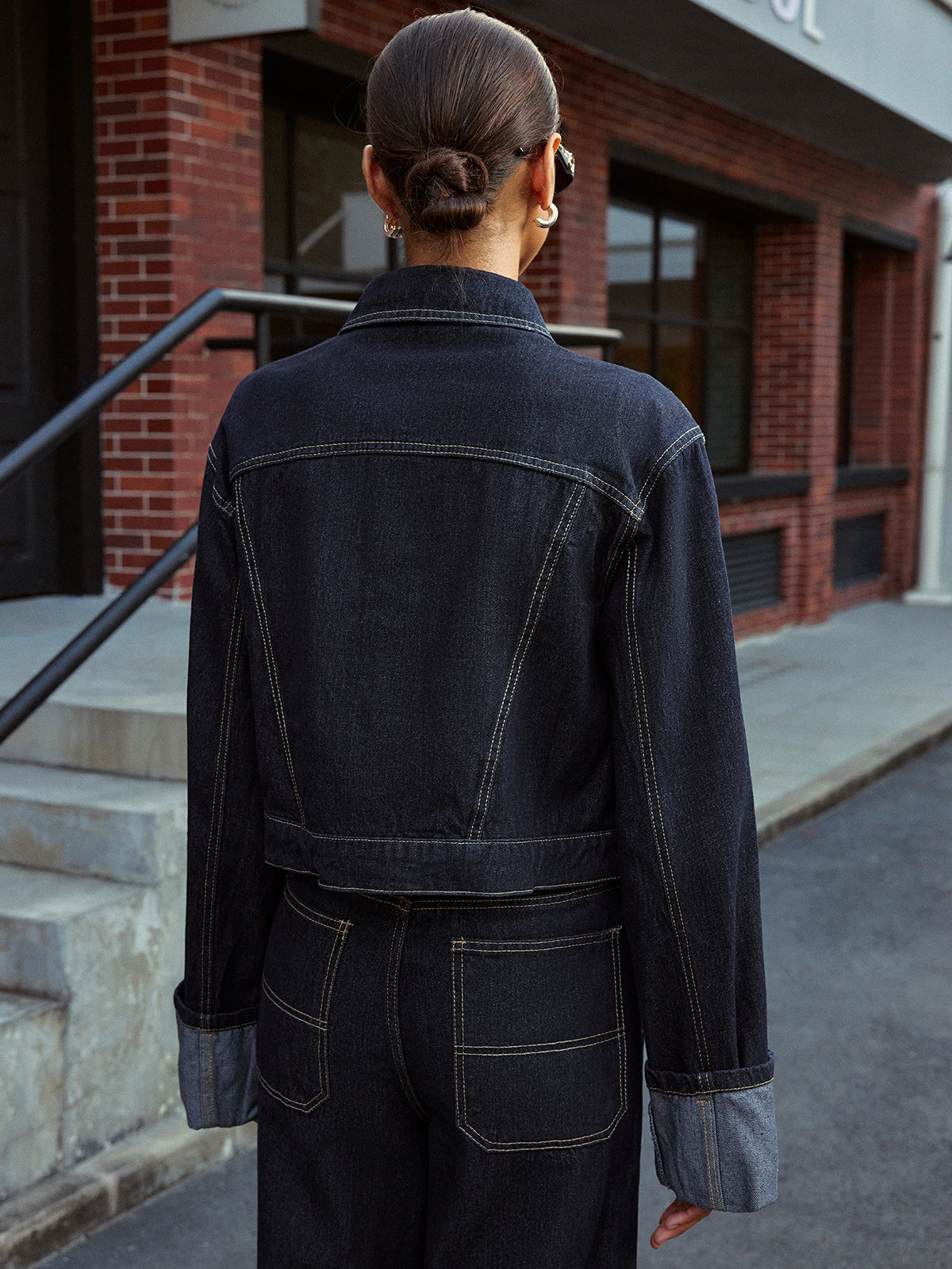 Aveline blue denim jacket, back view showing the yoke seams and turned-back cuffs