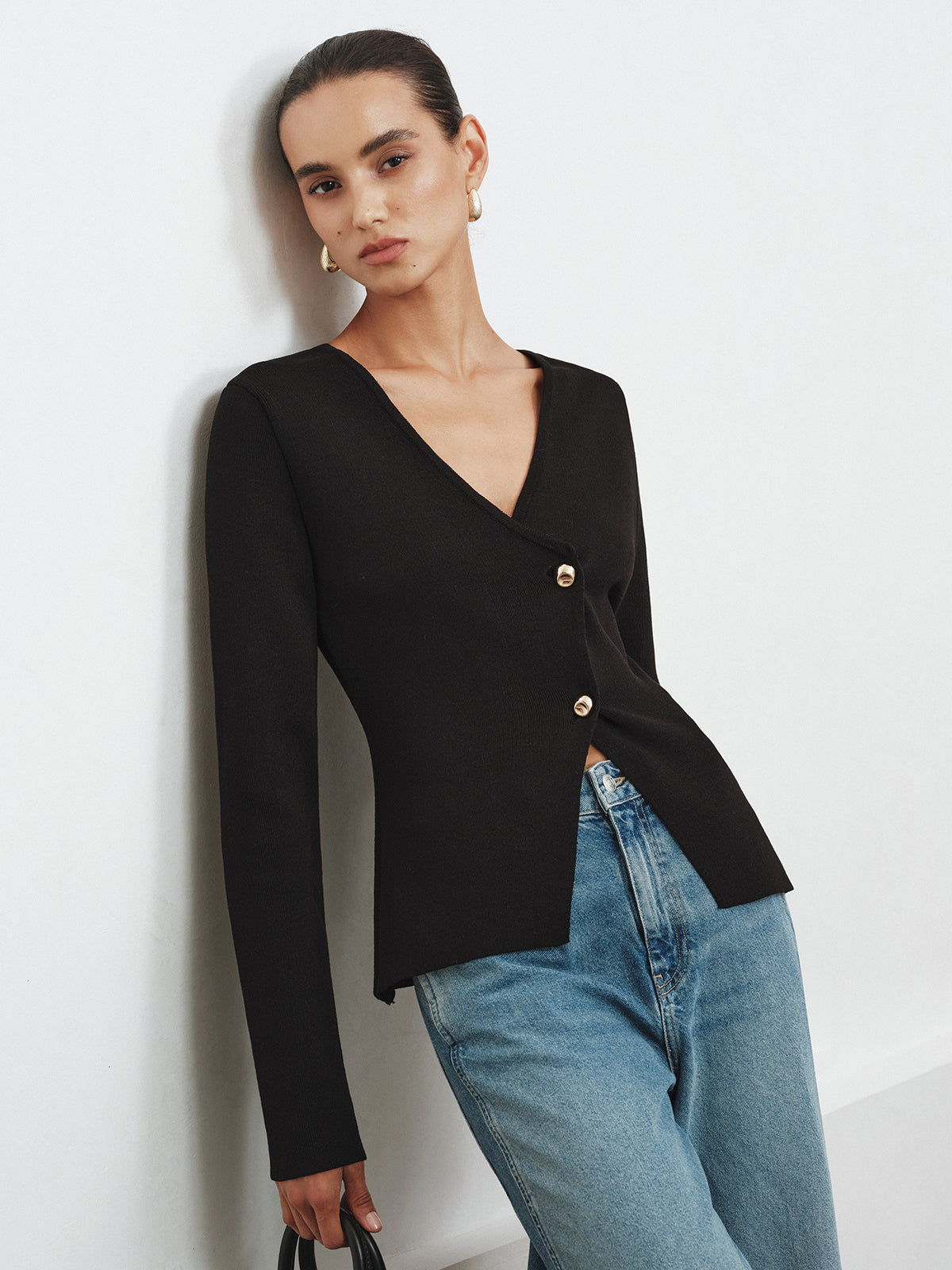 Bertille black V-neck cardigan worn with wide-leg jeans, angled view