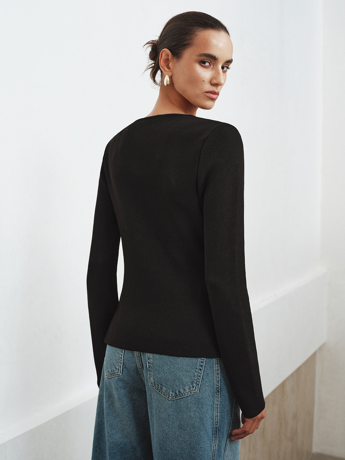 Bertille black cardigan showing the curved hem and side split, back view