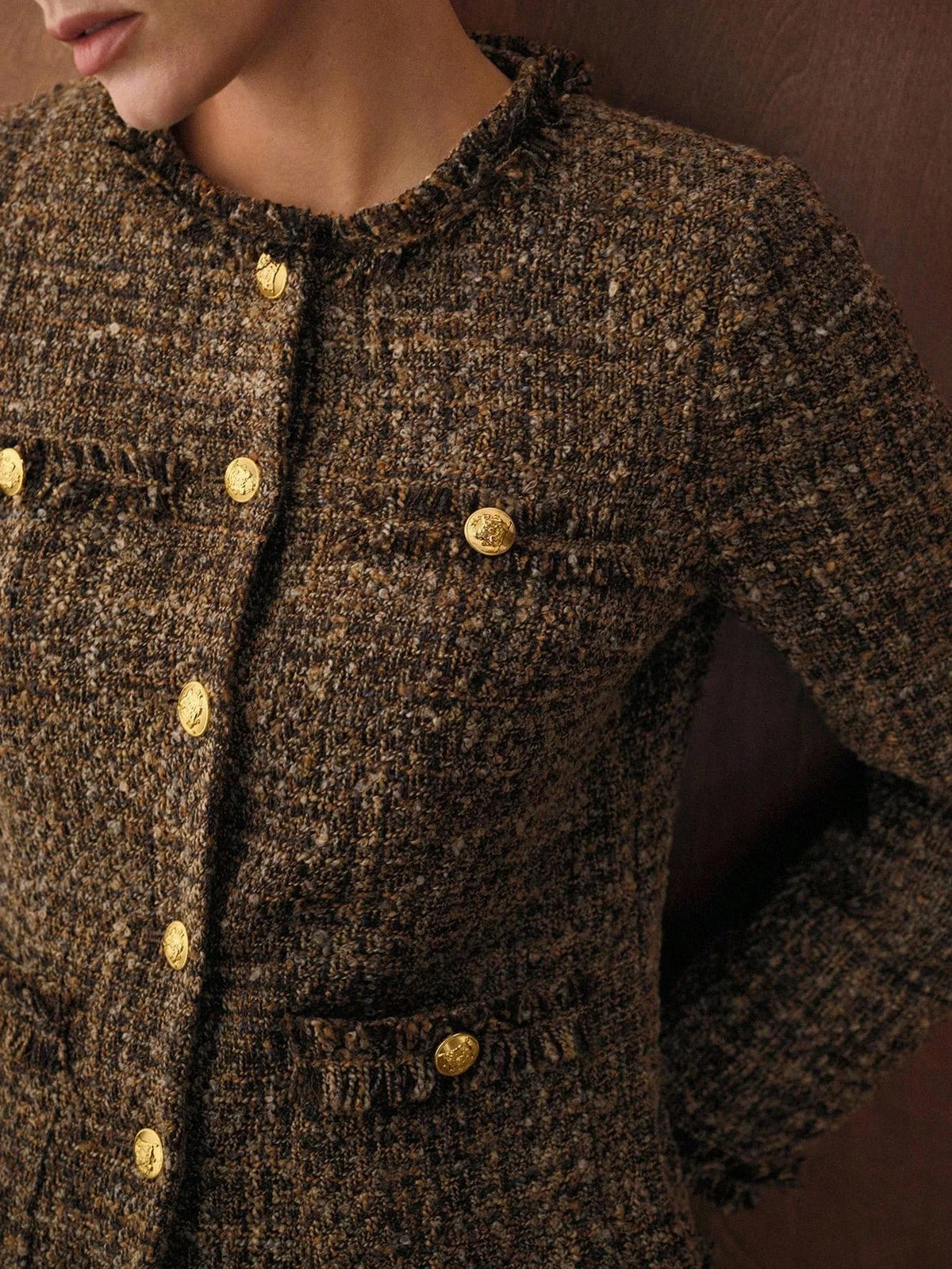 Close-up of the gold buttons and frayed trim on the Camille tweed jacket