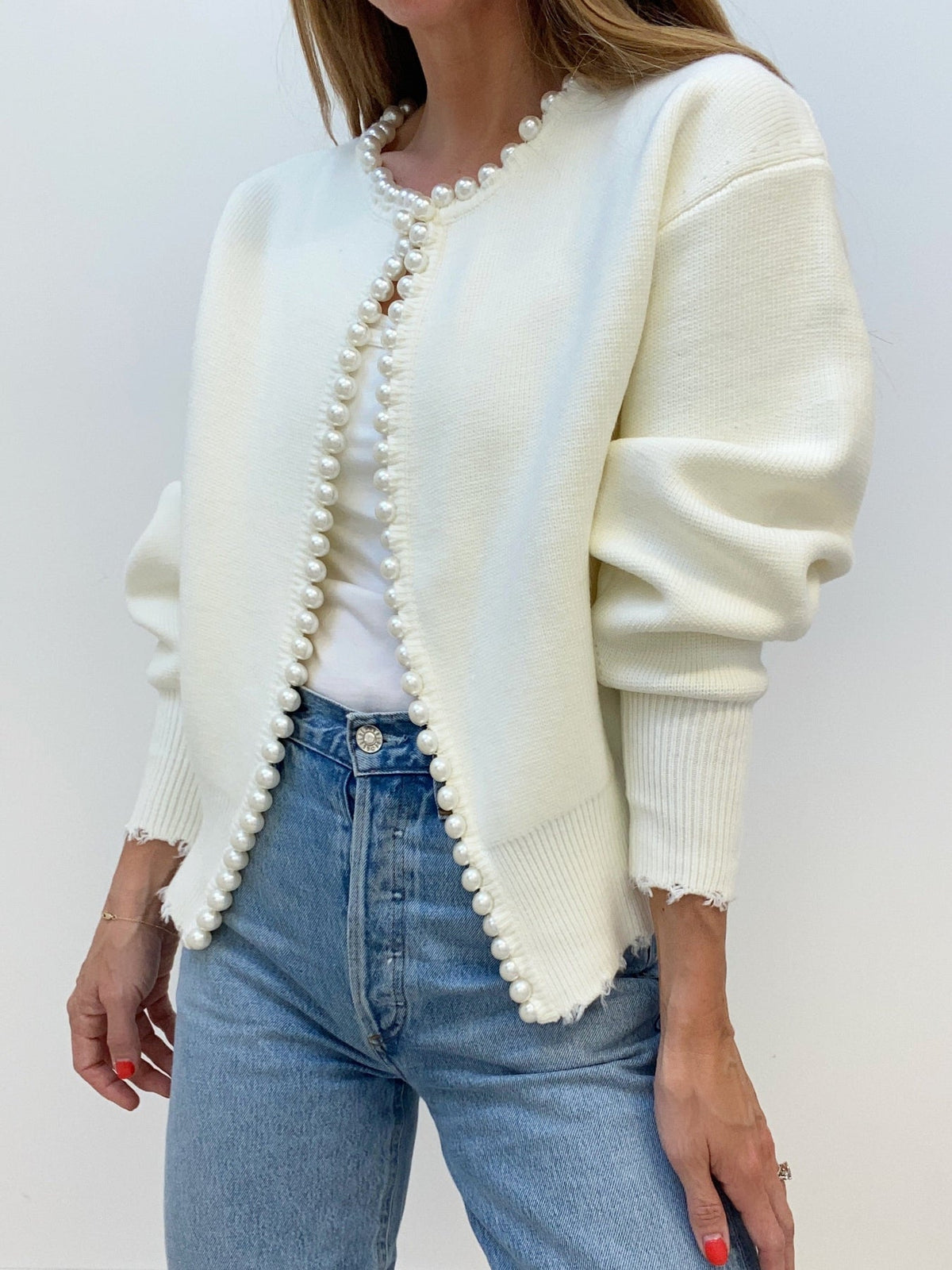 Cream open-front cardigan edged with pearl beading, worn with light-wash jeans