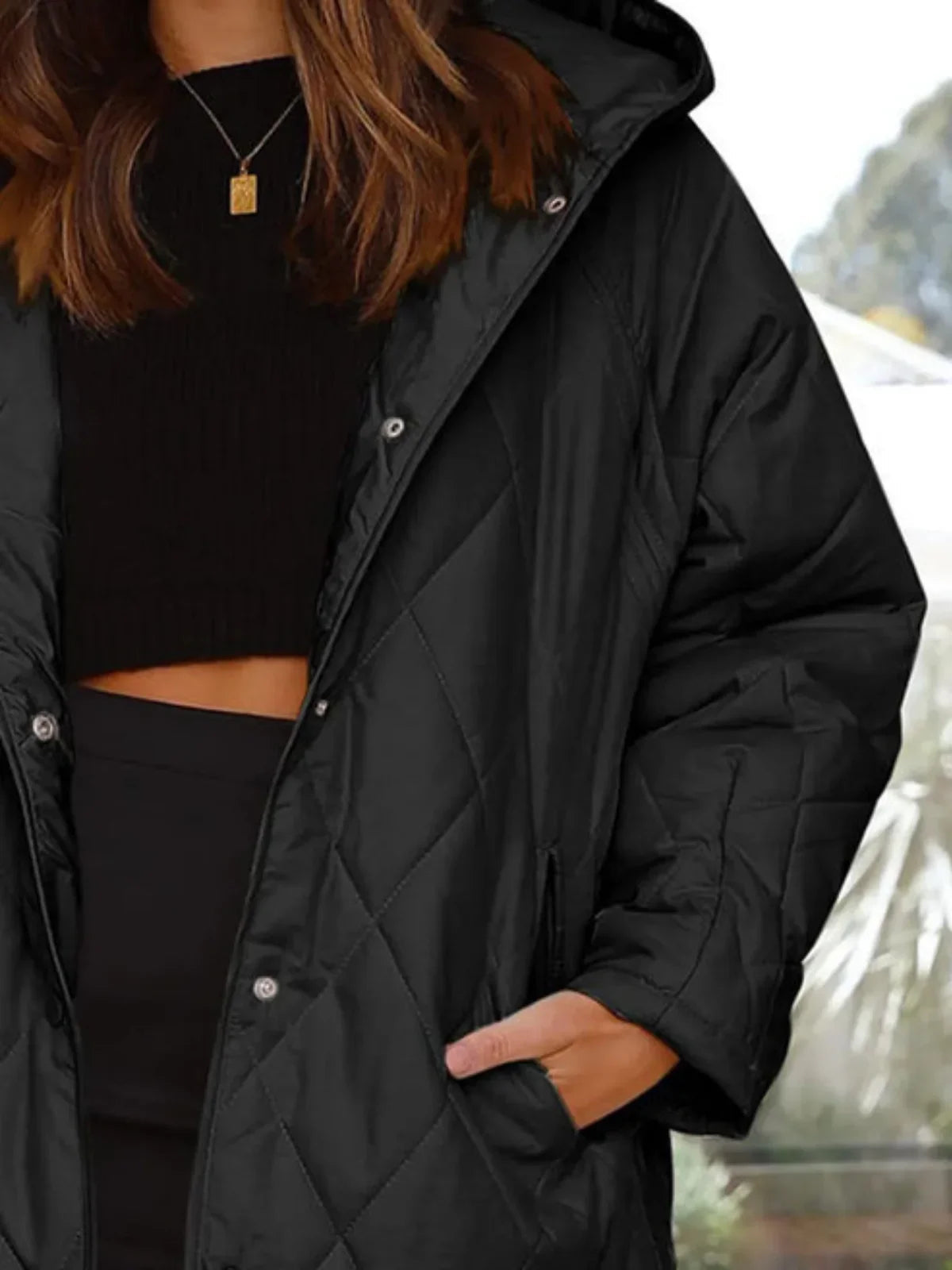 Eleonore black quilted coat shown from the side with the hood