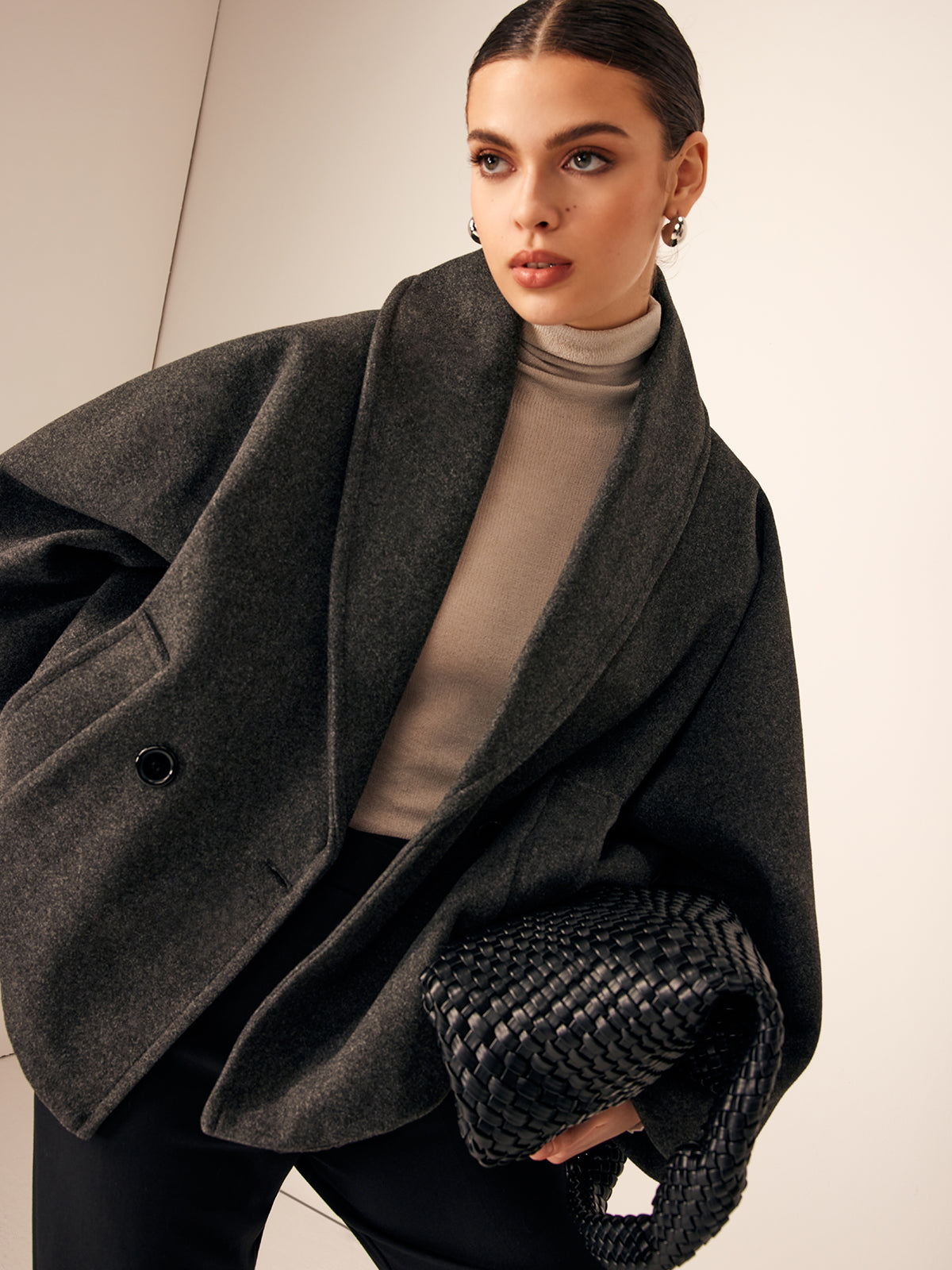 Gray oversized jacket worn over a cream roll-neck, close front view