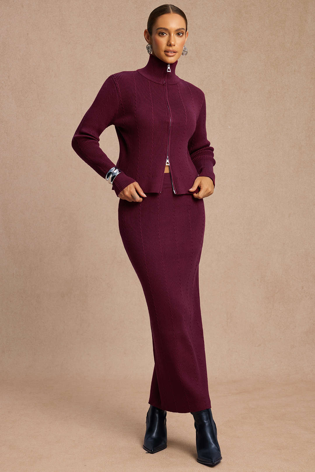 Woman wearing a burgundy zip-front knit jacket with a matching ribbed maxi skirt