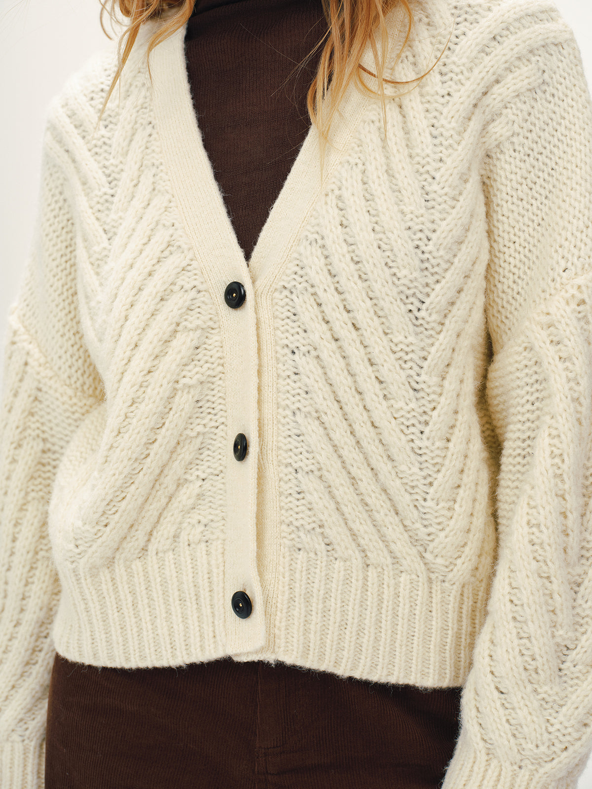 Isaure cream chevron chunky knit cardigan, close-up of the black buttons