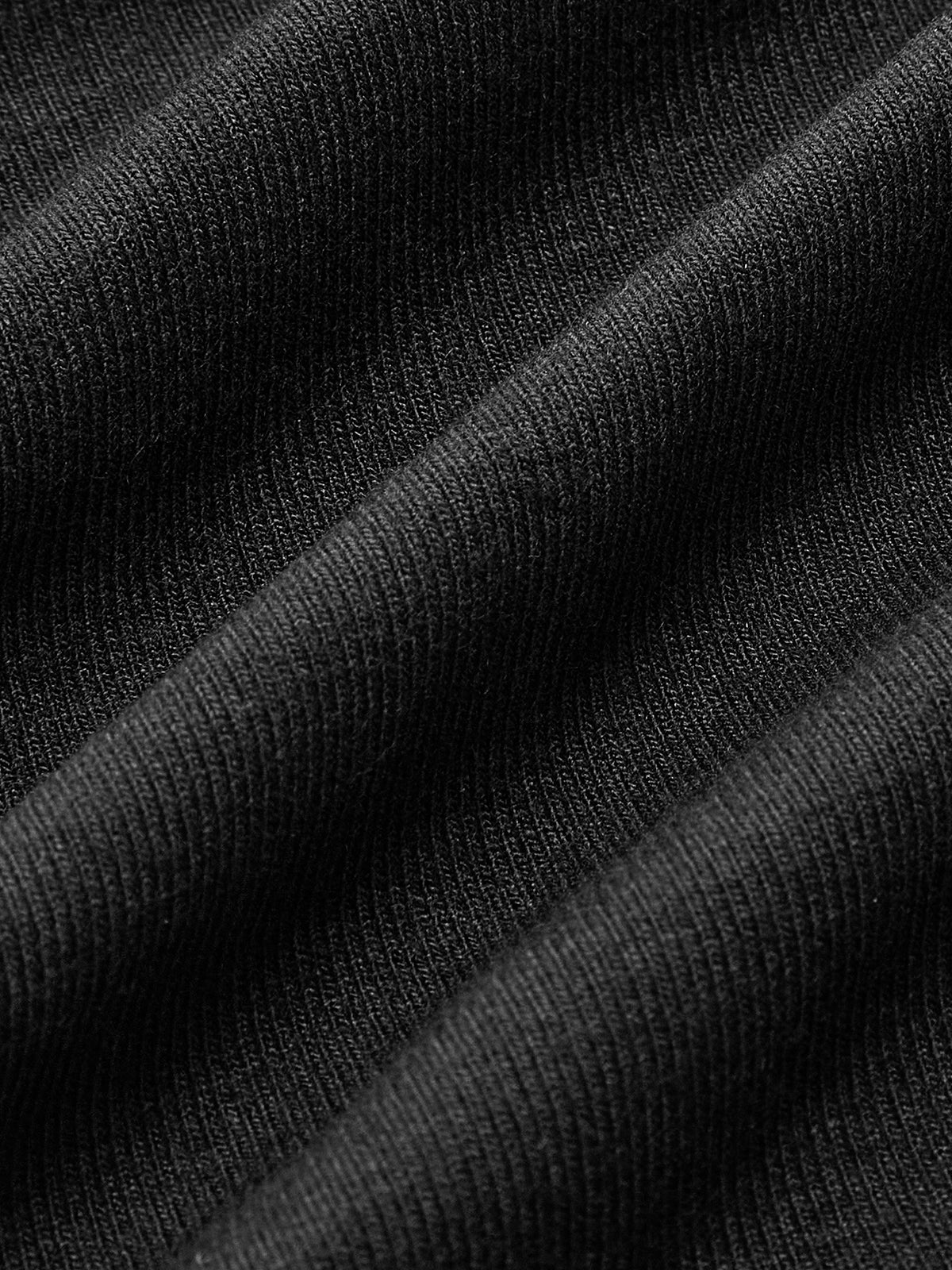 Joelle black asymmetric cutout turtleneck top, close-up of the fine ribbed jersey knit