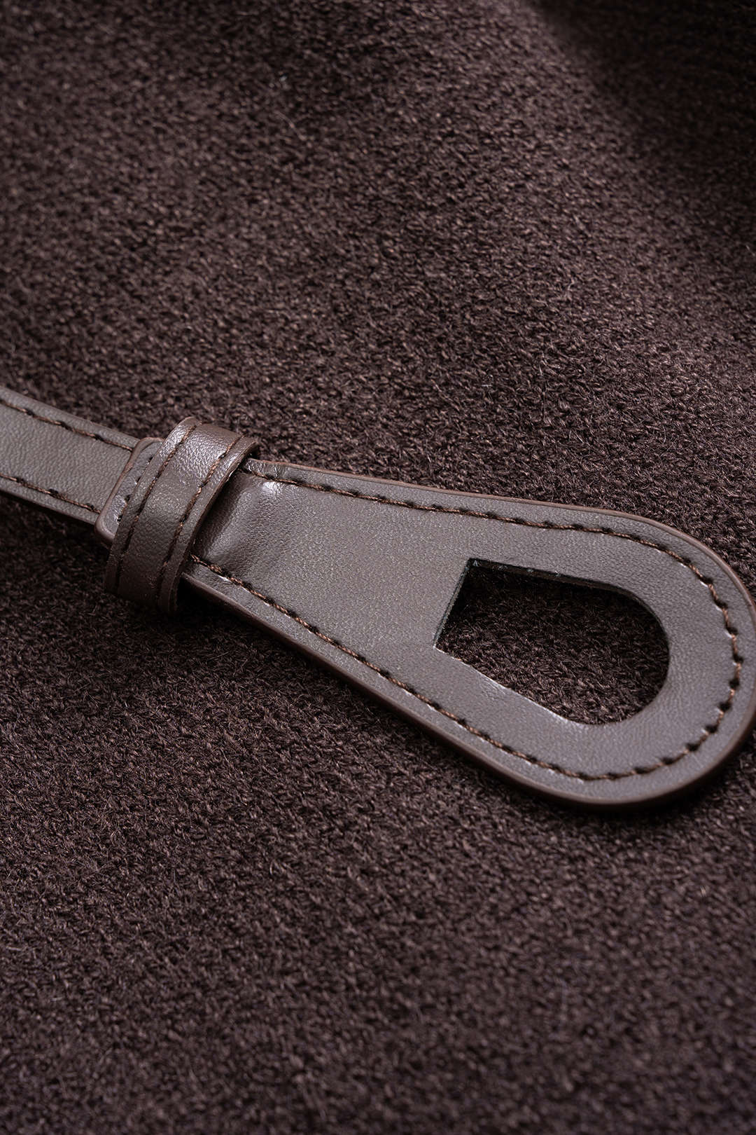 Close-up of the buckled strap belt on the Leontine jacket