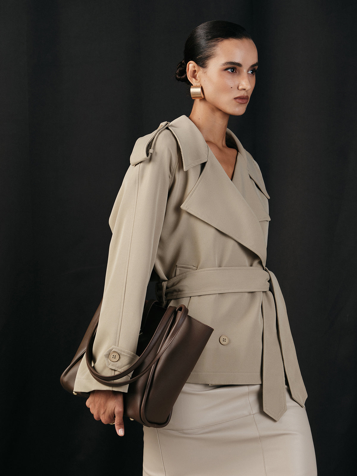 Khaki cropped trench jacket seen from the side, belt tied at the waist