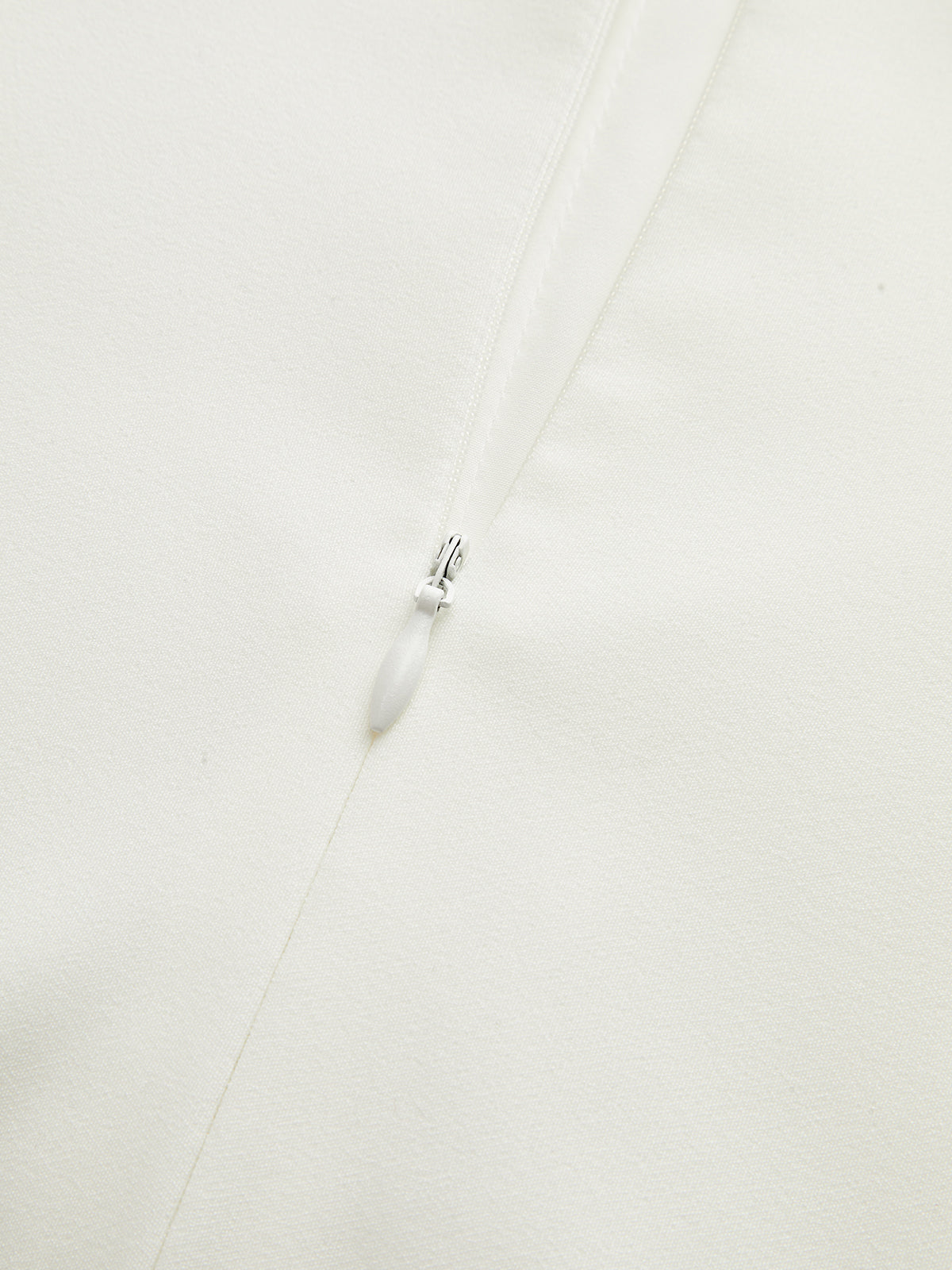 Milene white pleated mini dress, close-up of the concealed back zip