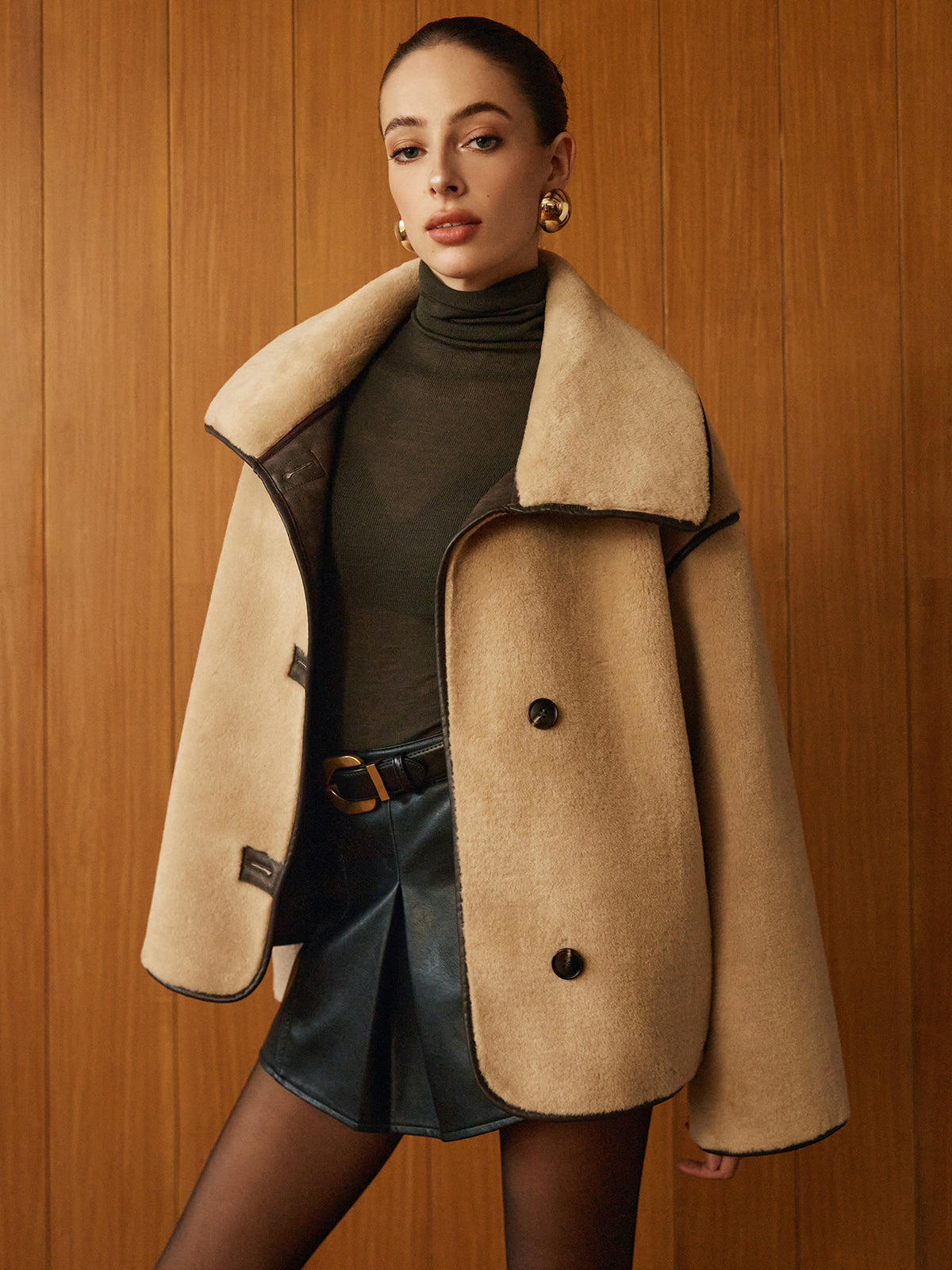 Beige jacket with a high folded collar and dark contrast trim, front view
