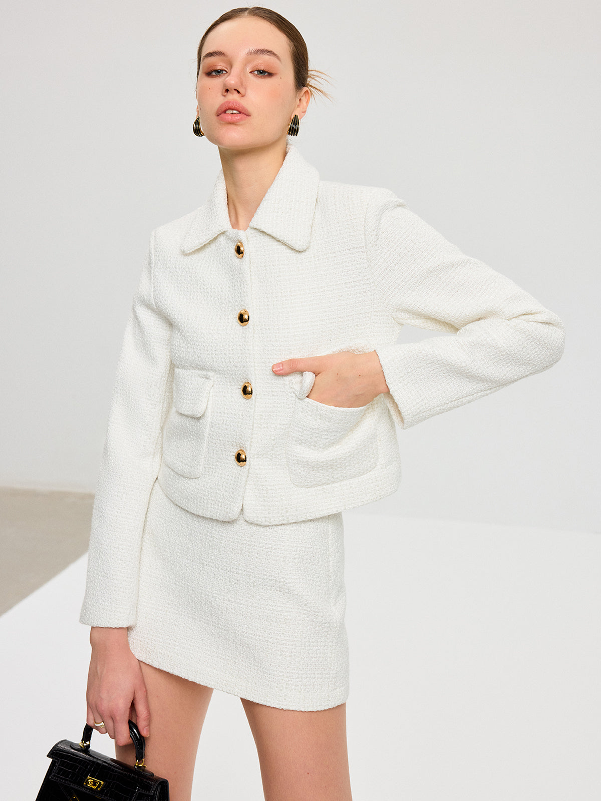 Quitterie white bouclé jacket and mini skirt set, hand inside the jacket flap pocket