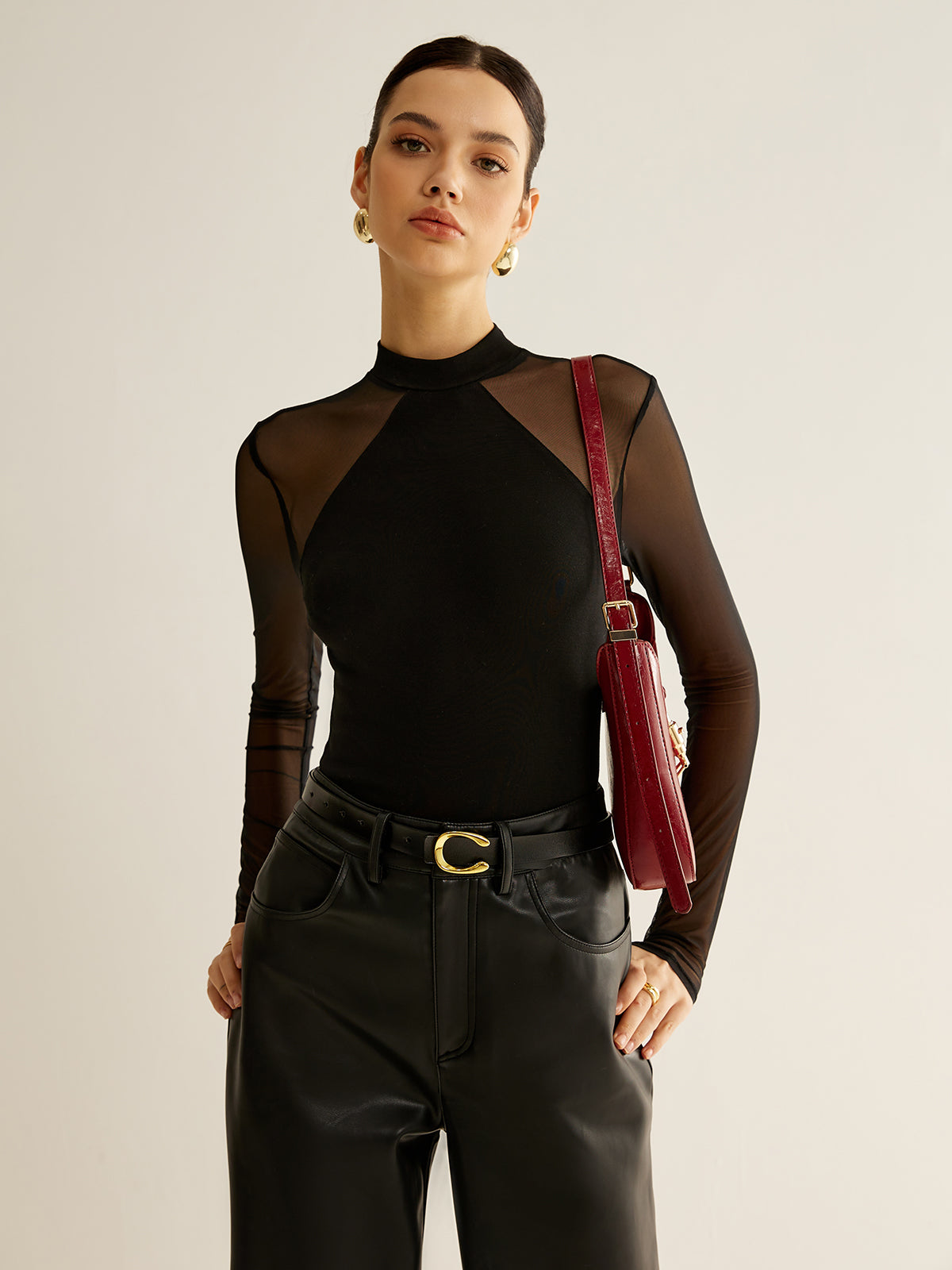 Severine fitted black blouse showing the angled seam across the opaque body panel