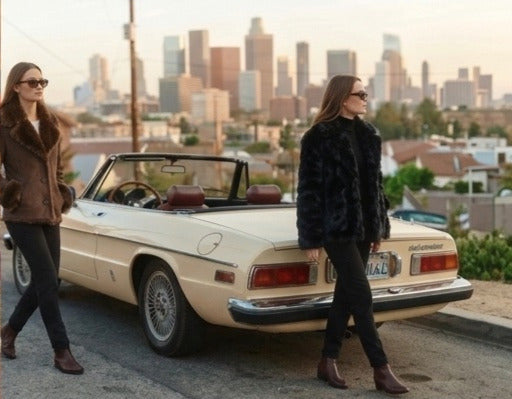 Two women in autumn jackets walking past a vintage car