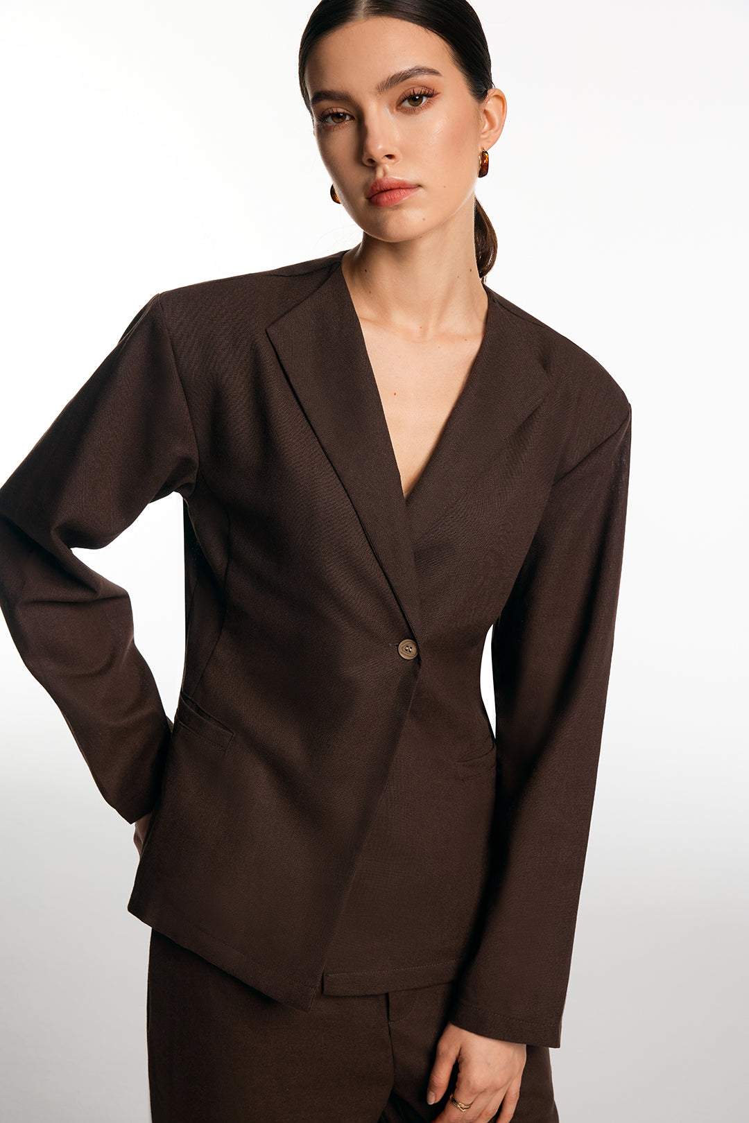 Front view of the brown single-button blazer showing the notch lapel and deep V neckline