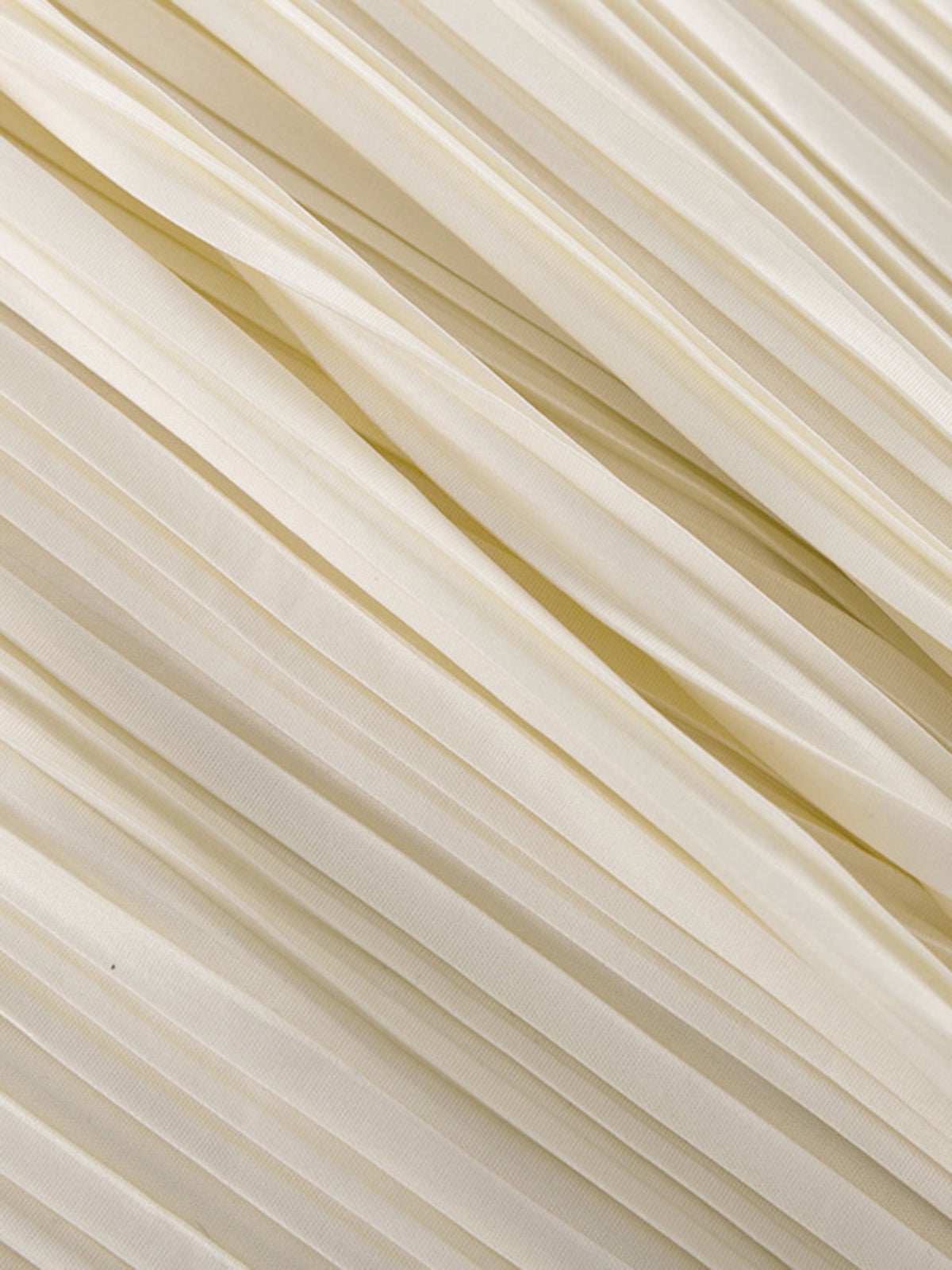 Close-up of the fine all-over pleating on the cream fabric