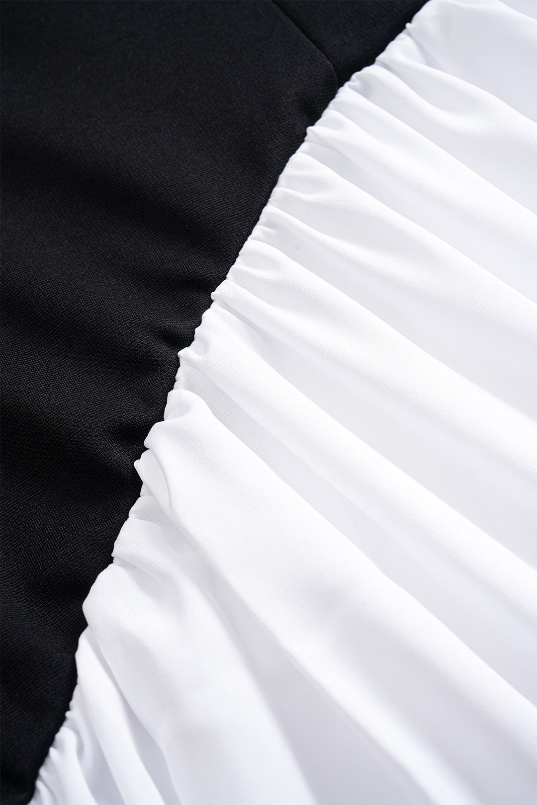 Constance maxi dress, close-up of the diagonal seam where black meets gathered white