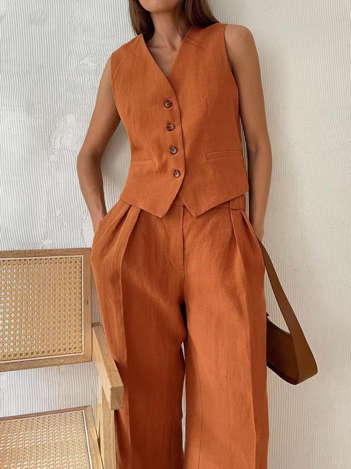 Alix terracotta waistcoat and wide-leg trousers, close-up of the button front and welt pockets