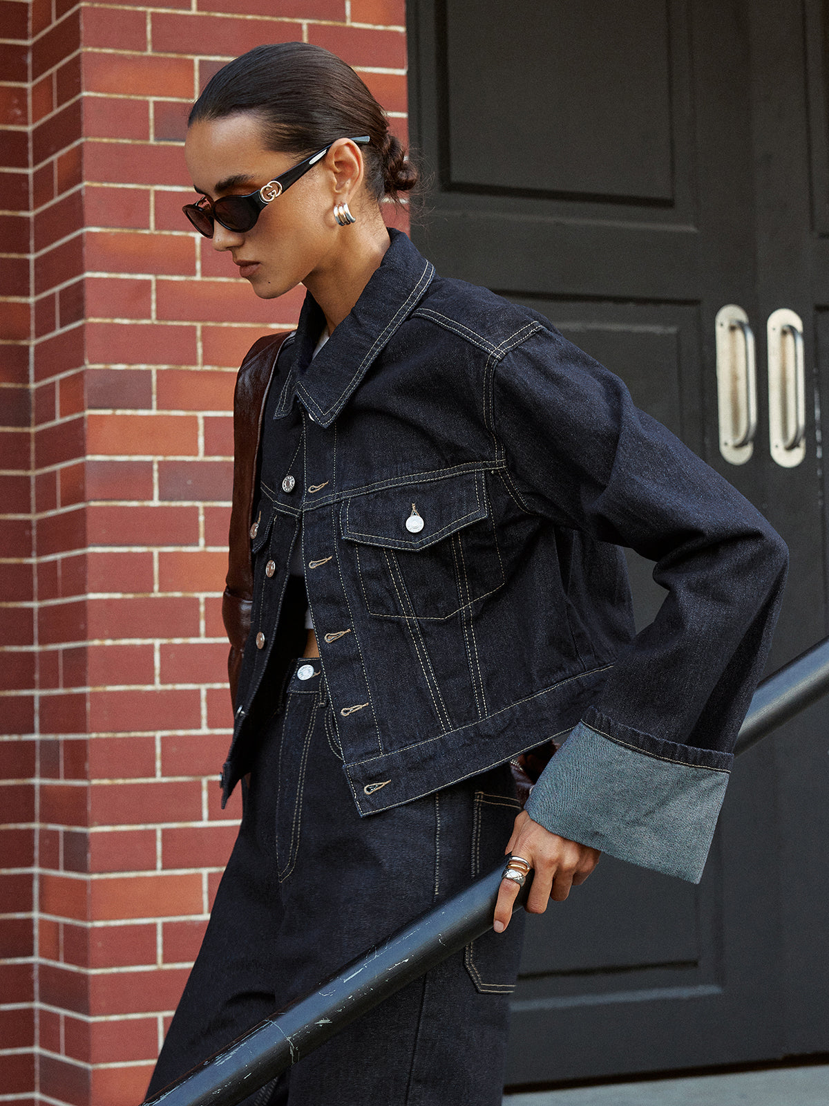 Aveline blue denim jacket worn open, side view with wide turned-back cuff at the wrist
