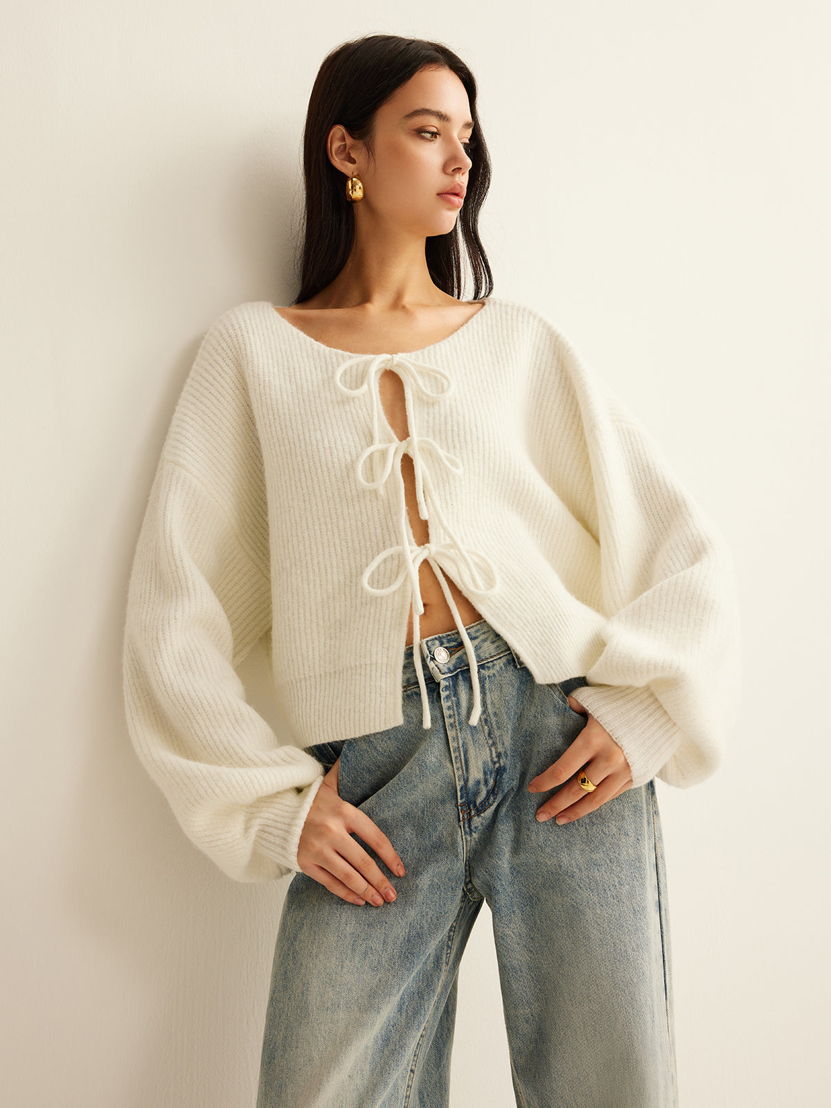 Cream ribbed cardigan with three tie-bow fastenings and balloon sleeves, front view