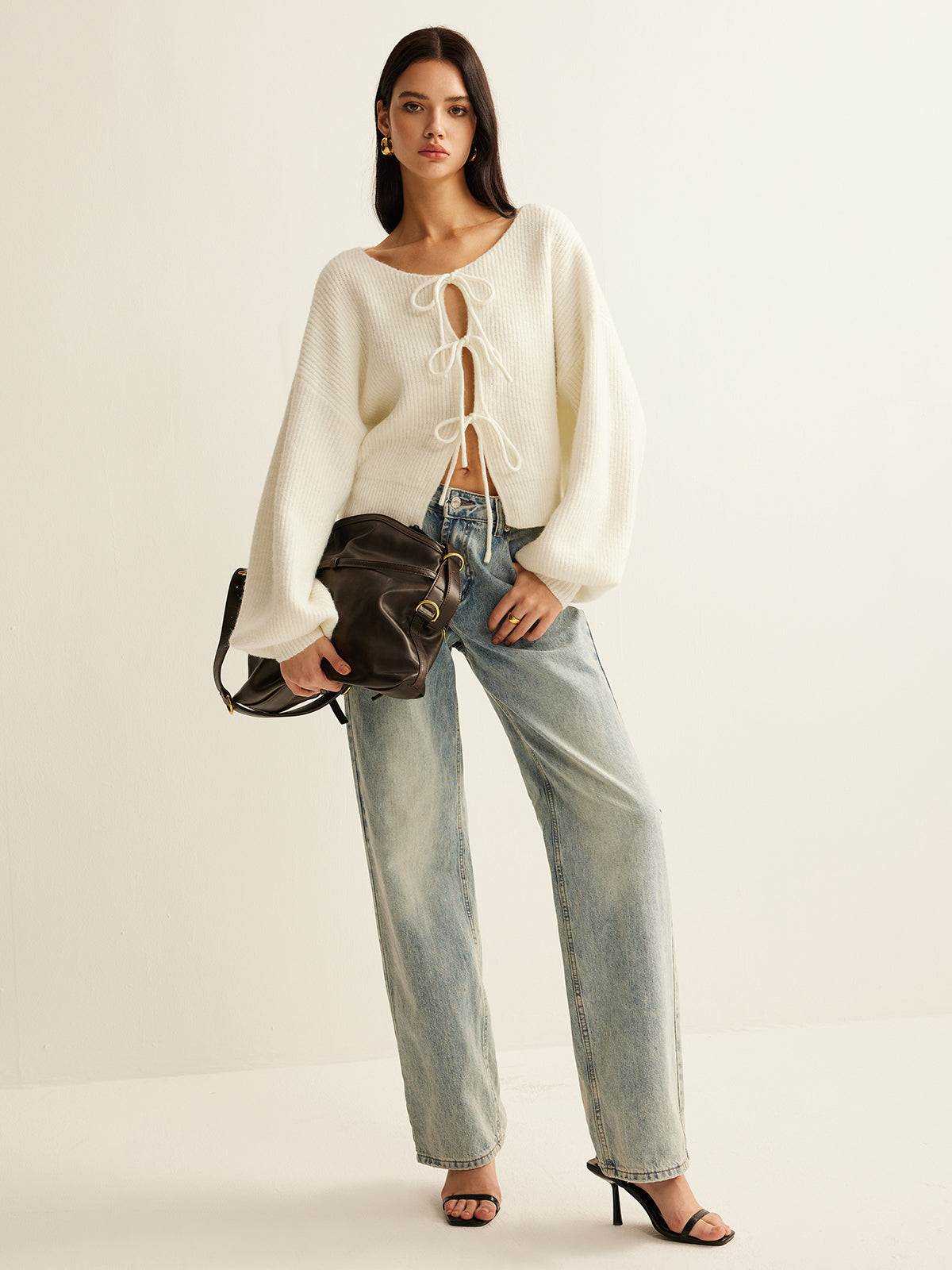 Full-length view of the cream tie-front cardigan worn with light-wash wide-leg jeans