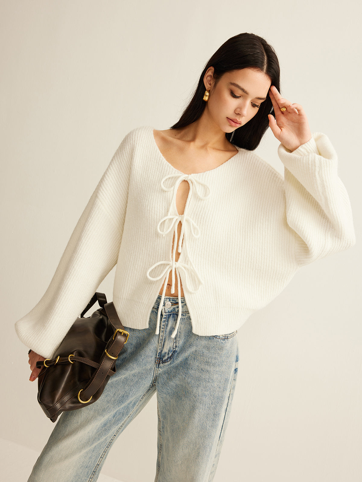 Cream balloon-sleeve cardigan seen from the side, showing the full sleeve volume