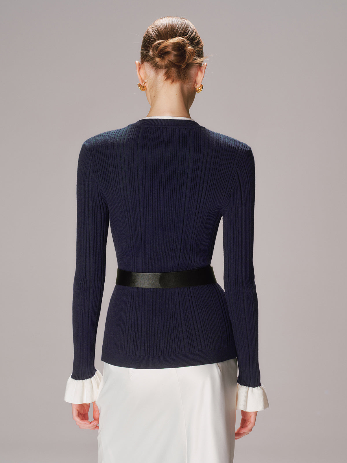 Beatrice navy ribbed knit cardigan, back view showing the belt and ribbed cuff