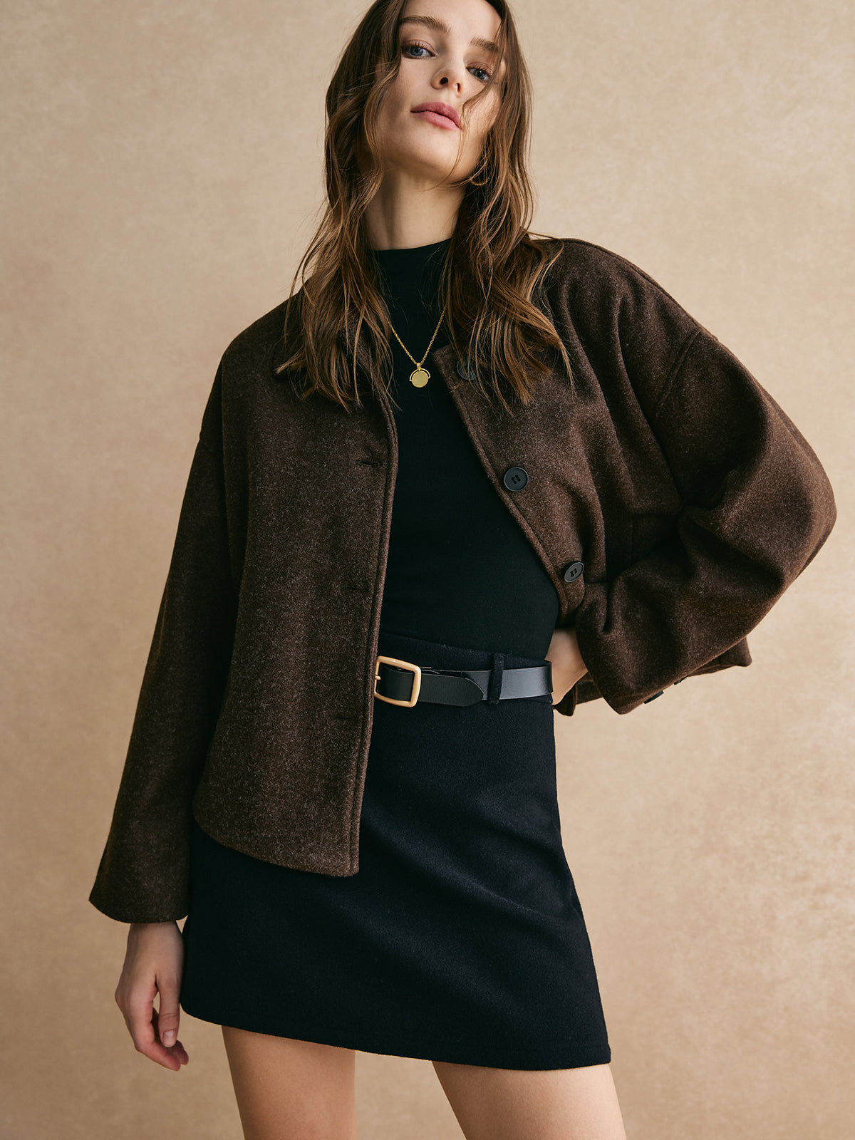 Bettina brown oversized button-front jacket worn open over a black top, hand-on-hip front view