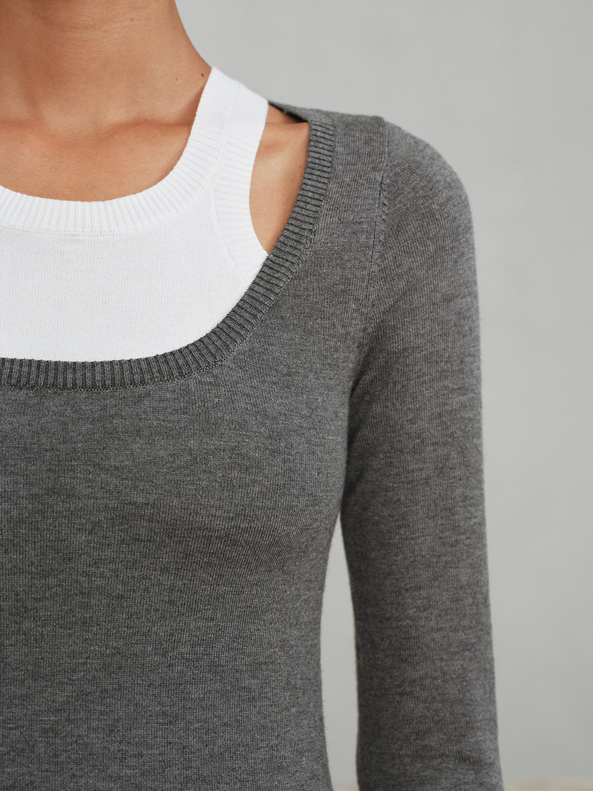 Carine gray layered shoulder cutout knit top, close-up of the shoulder cutout and layered neckline