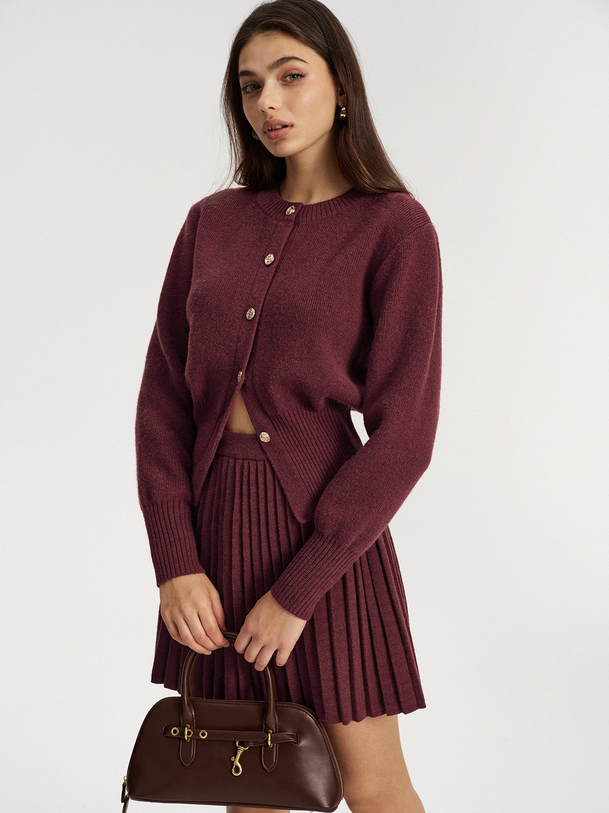 Side view of the burgundy cardigan and pleated knit mini skirt set