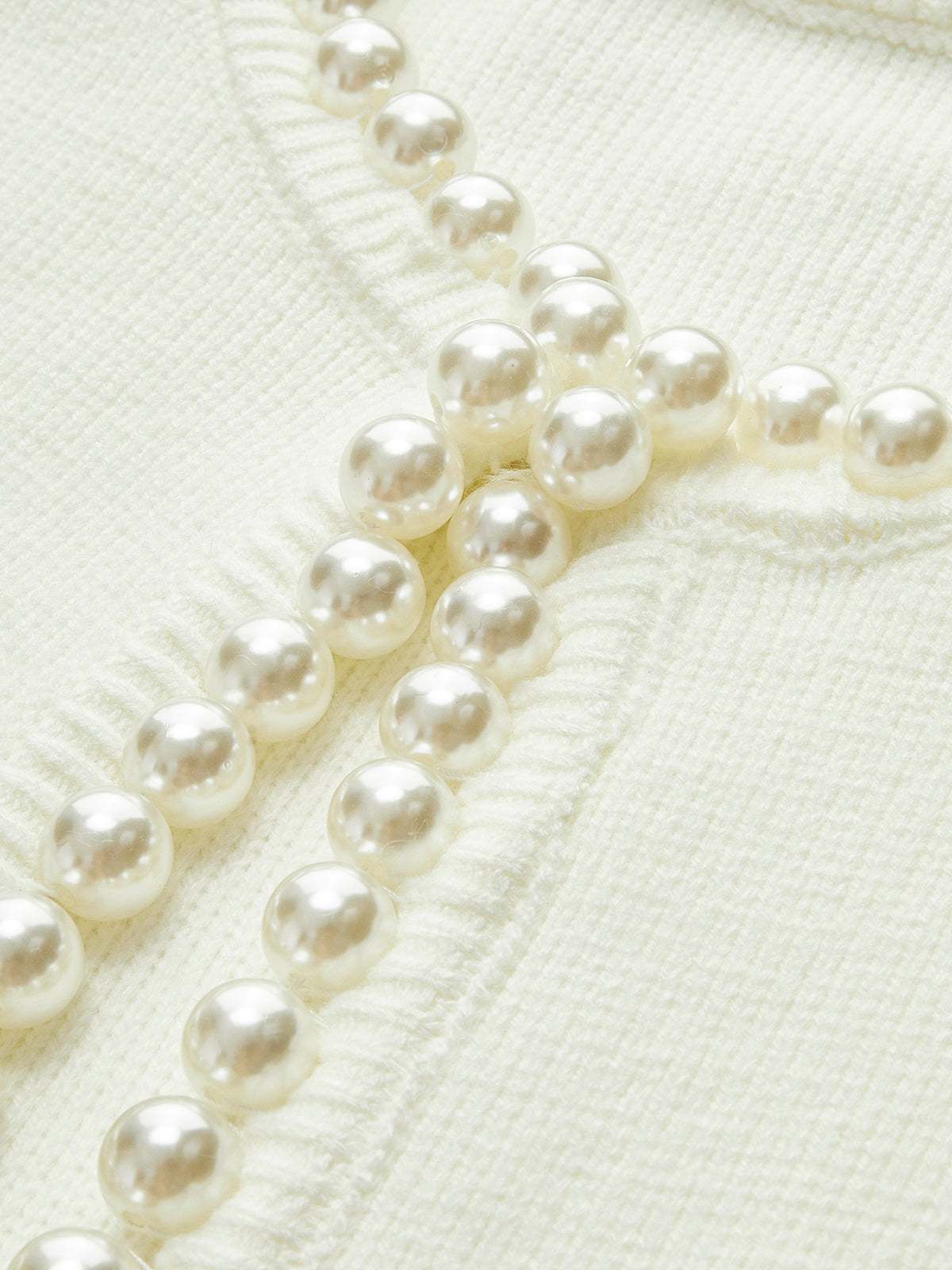 Close-up of the pearl beading around the cardigan's round neckline