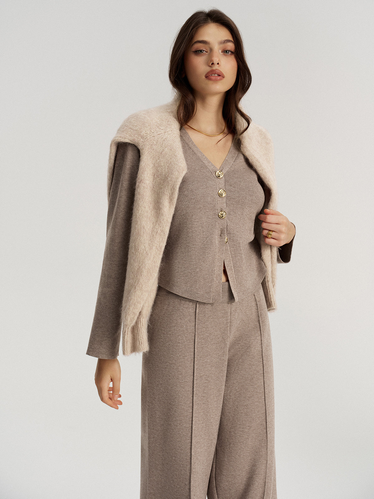 Taupe gold-button knit cardigan worn with matching wide-leg knit trousers