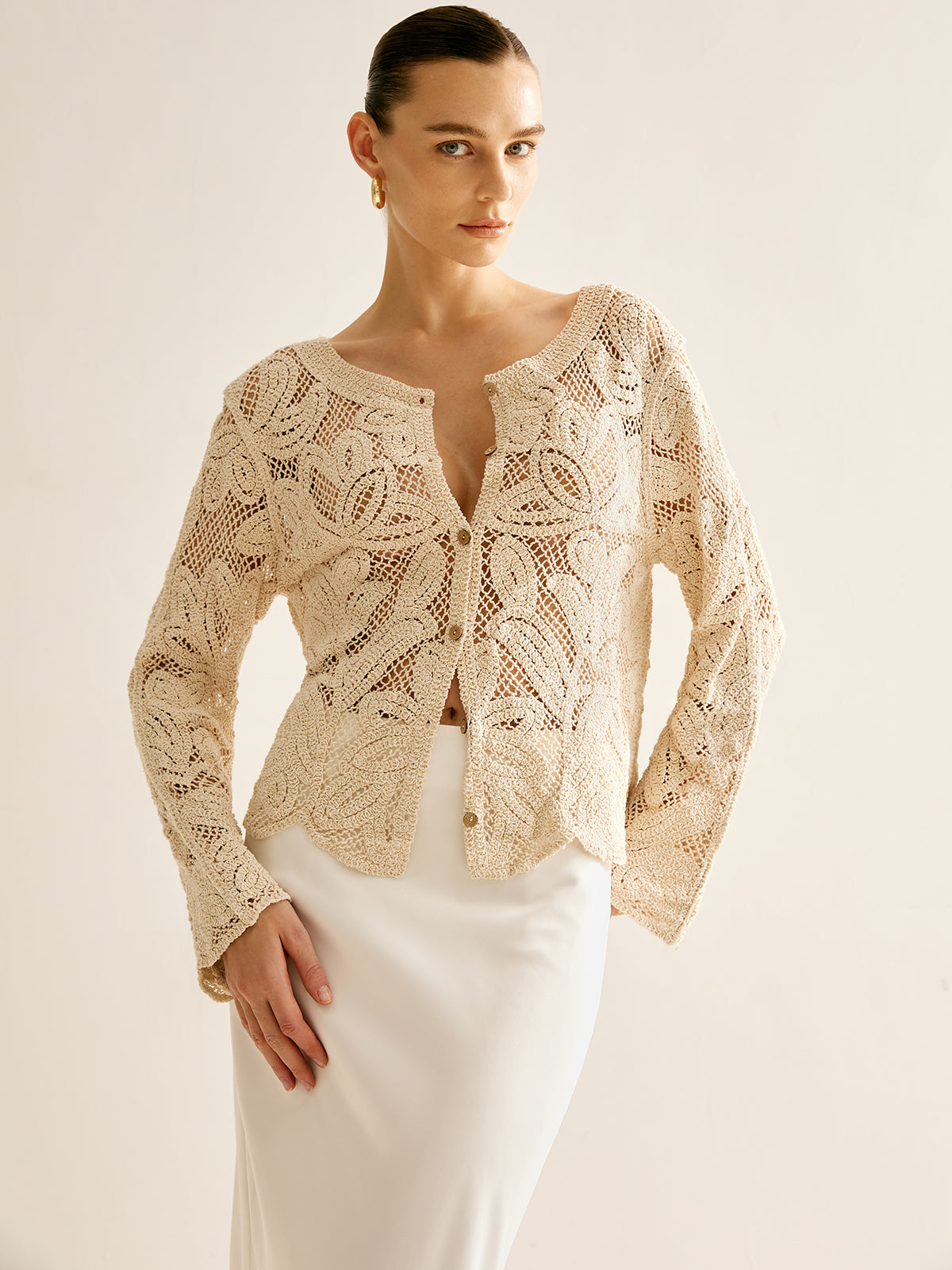 Cosette beige crochet openwork cardigan partly buttoned, three-quarter front view