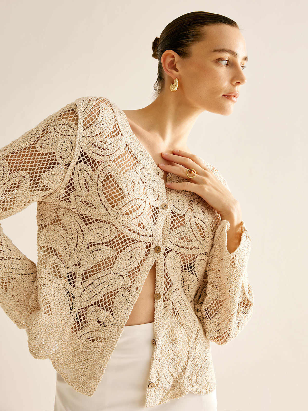Cosette beige crochet openwork cardigan, side view showing the open lace knit