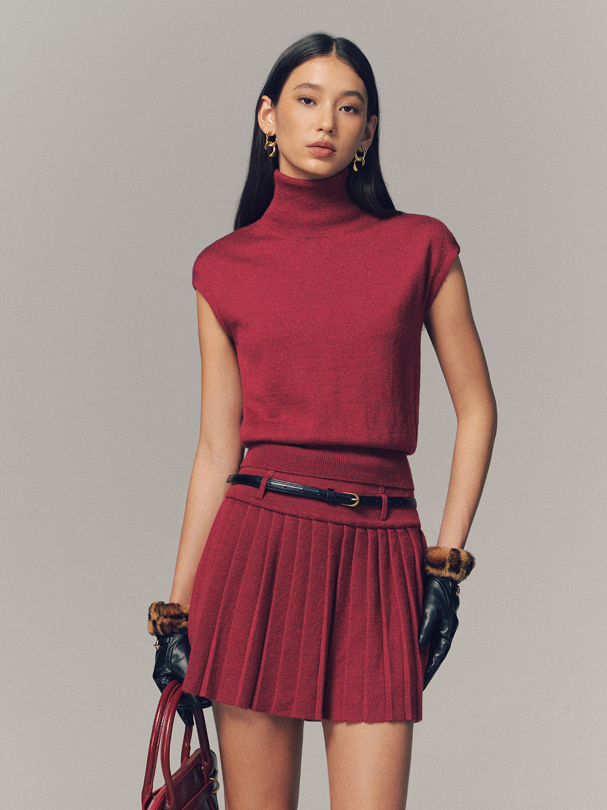 Edwige red knit two-piece set, funnel-neck top and pleated mini skirt, front view
