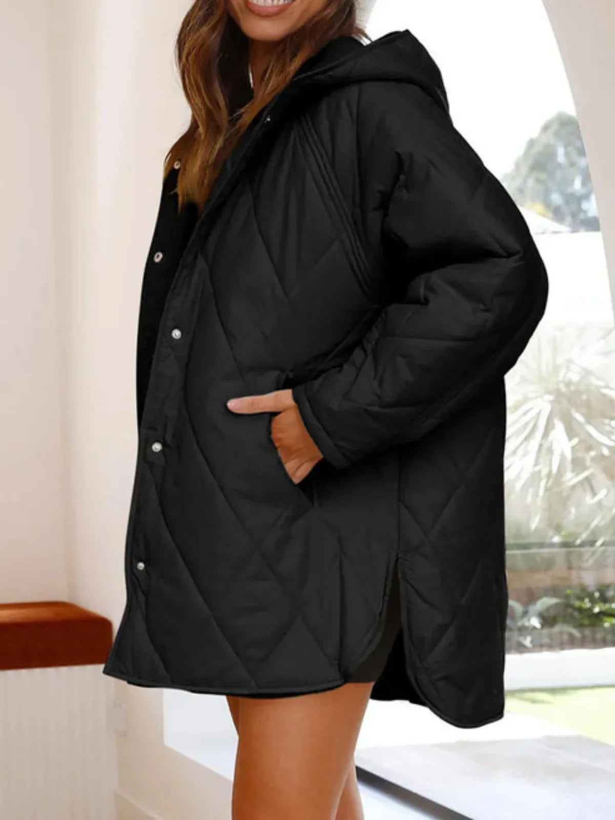 Eleonore black quilted coat fastened, with hands in the side pockets