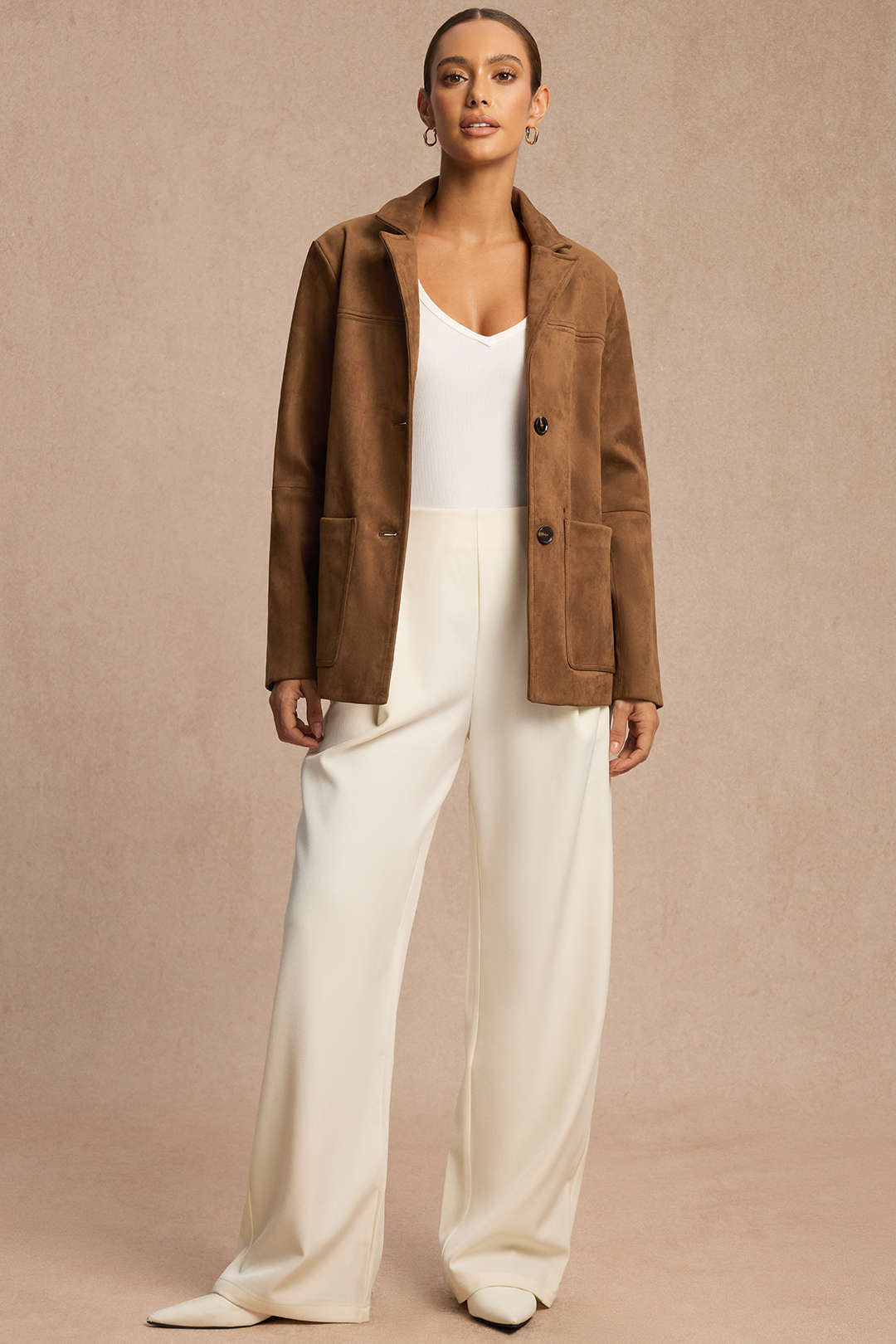 Eliette brown jacket worn open over white trousers, full-length view