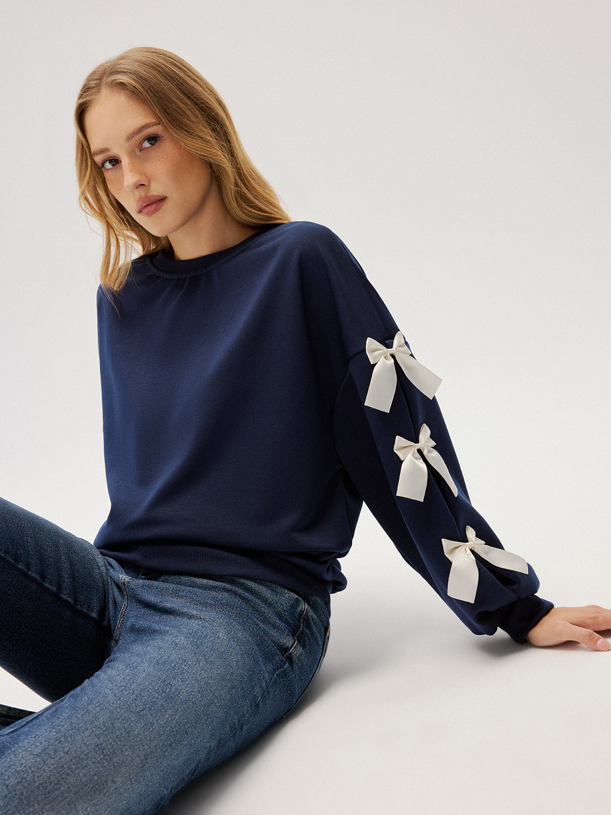Evelyne navy ribbon bow sleeve sweatshirt, close-up of the ribbed crew neckband