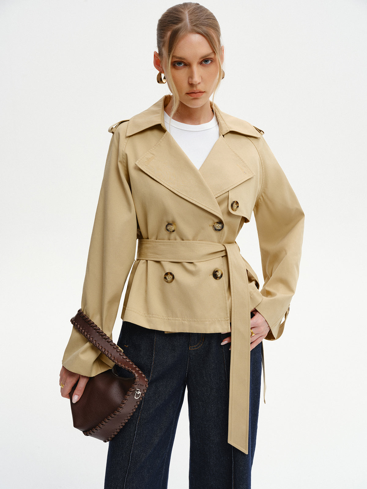 Khaki belted trench jacket worn with wide-leg jeans, front view