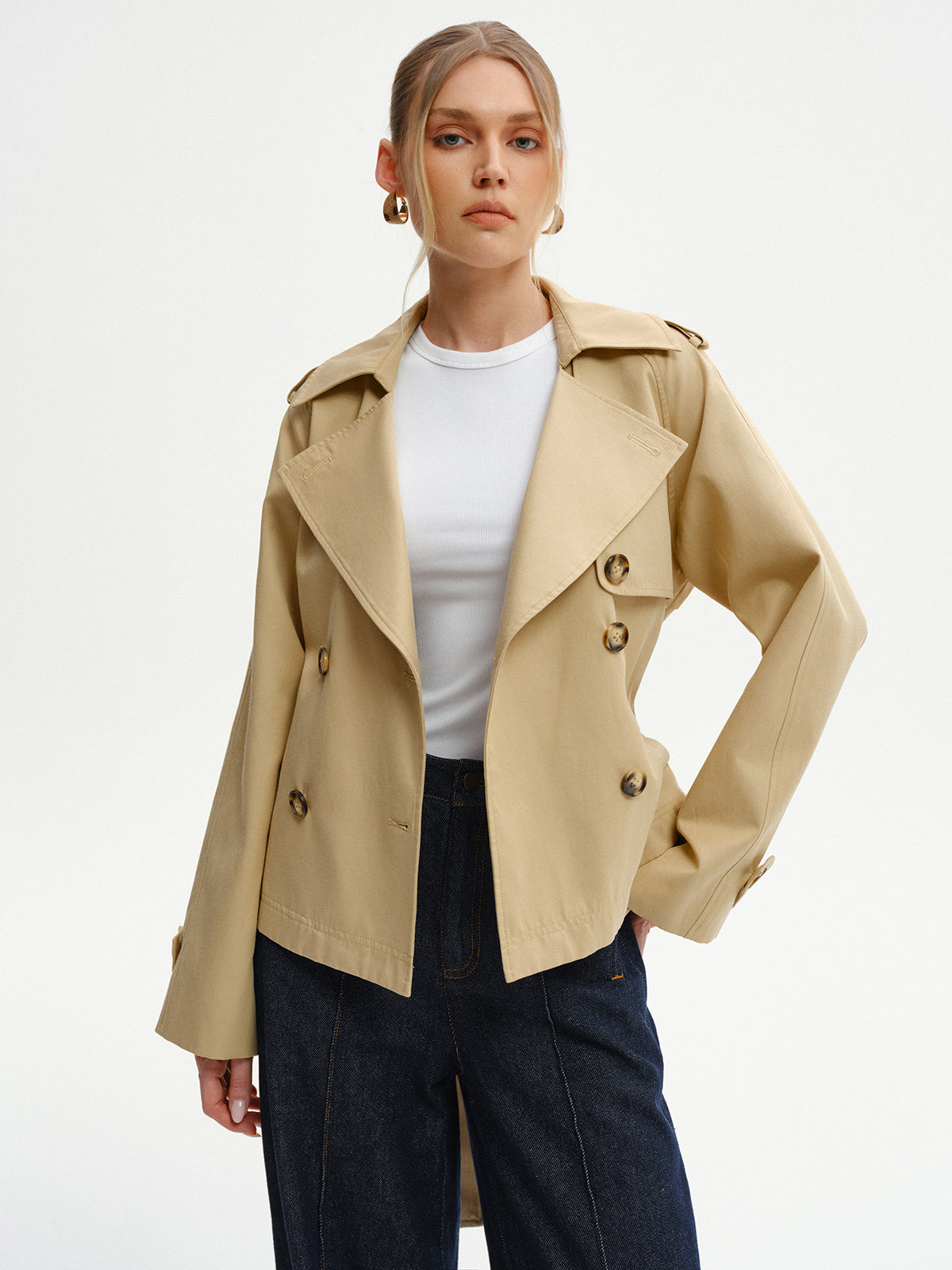 Khaki trench jacket worn open over a white top, front view