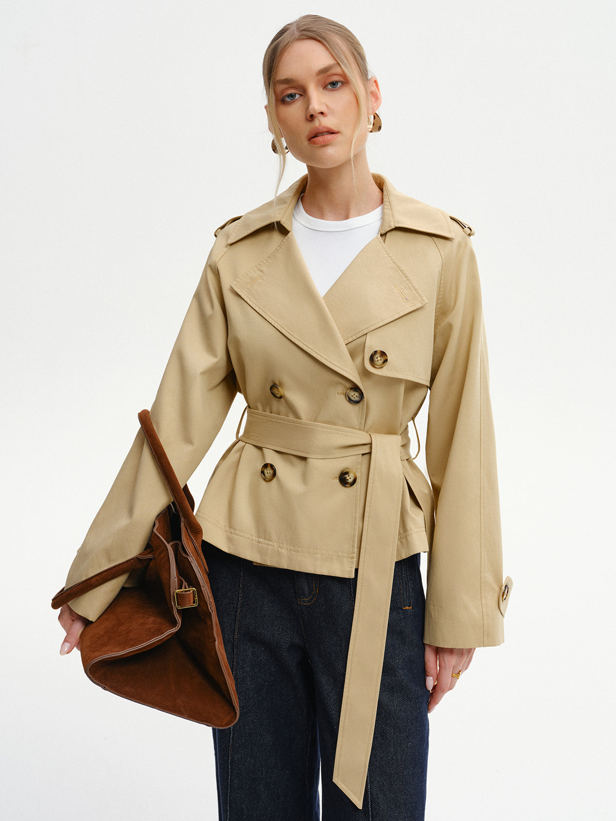 Khaki belted trench jacket worn with a shoulder bag, front view