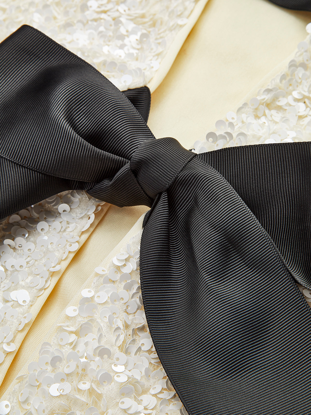 Fernande Cream sequin cropped jacket, close-up of a ribbon bow and the front edge