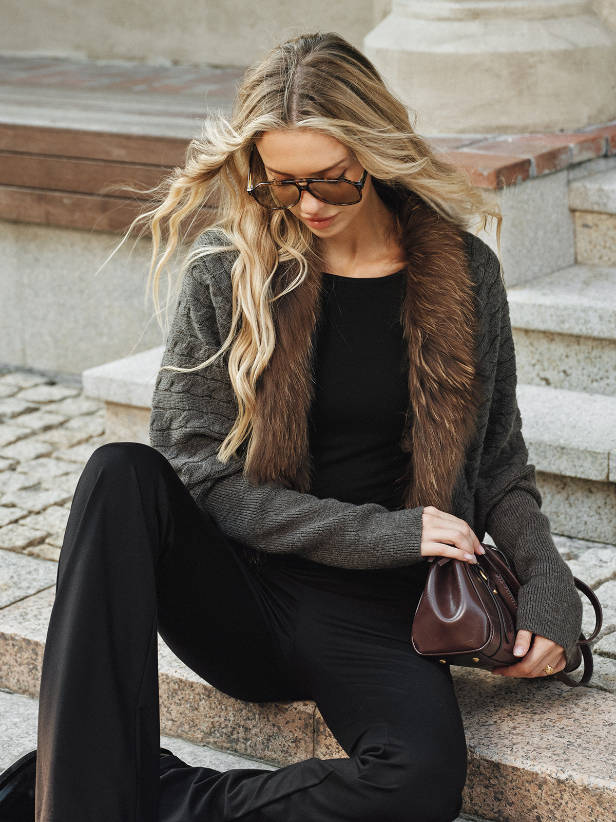Georgette gray knit jacket with faux fur collar worn open, seated front view