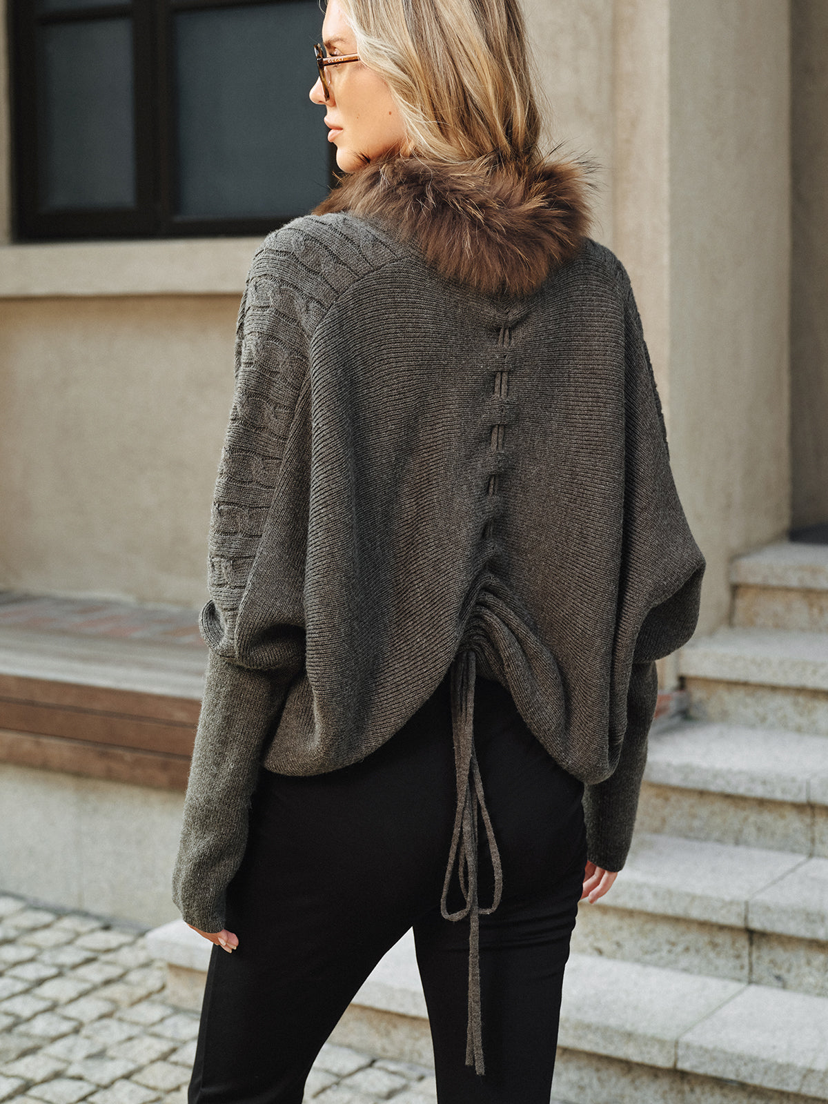 Georgette gray knit jacket, back view showing the center-back drawstring tie and faux fur collar